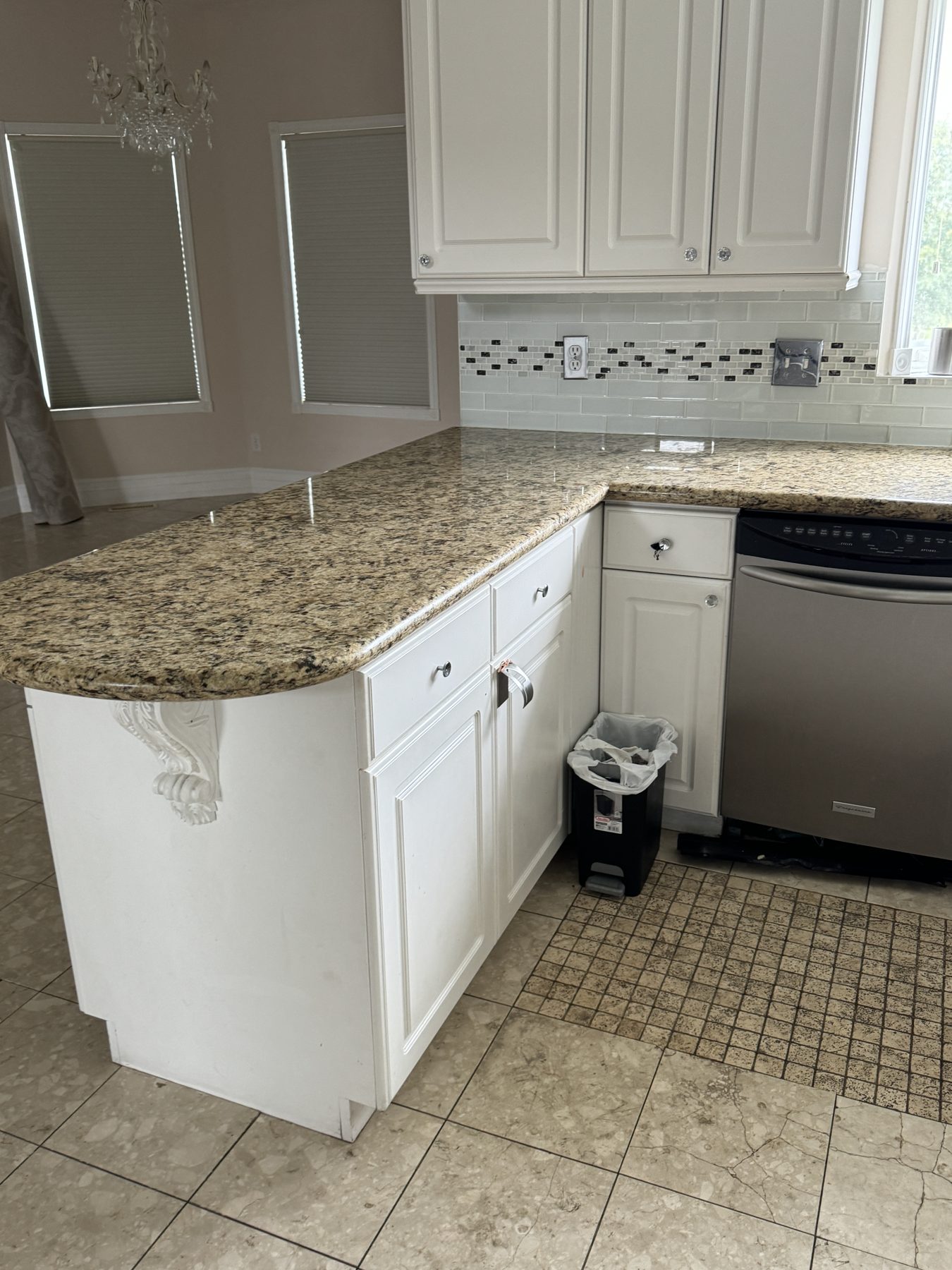 Kitchen island with granite countertop, white cabinets, and dishwasher — 14 Lochend Drive, Cochrane