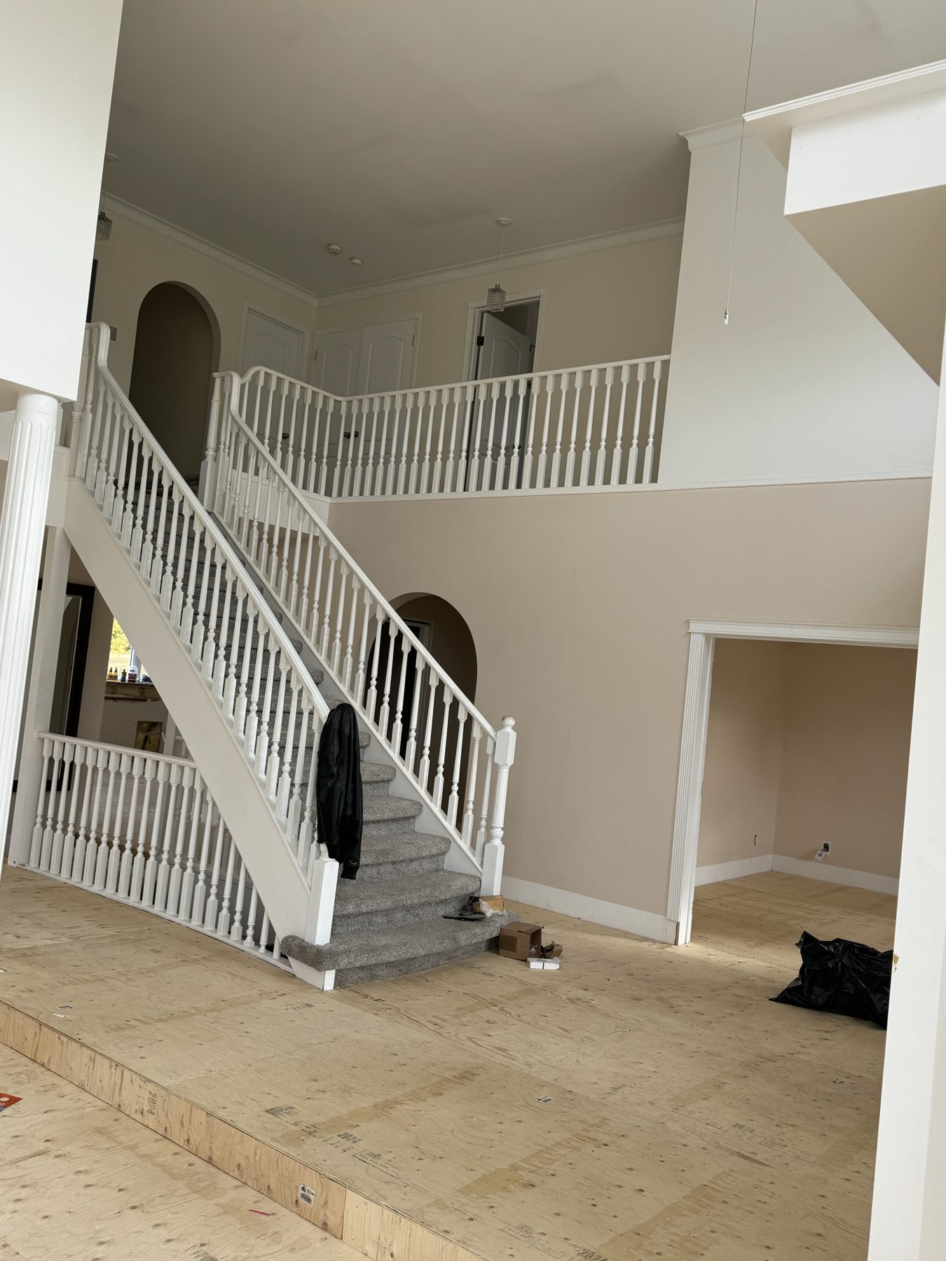 Interior renovation with plywood floors and a white staircase — 14 Lochend Drive, Cochrane