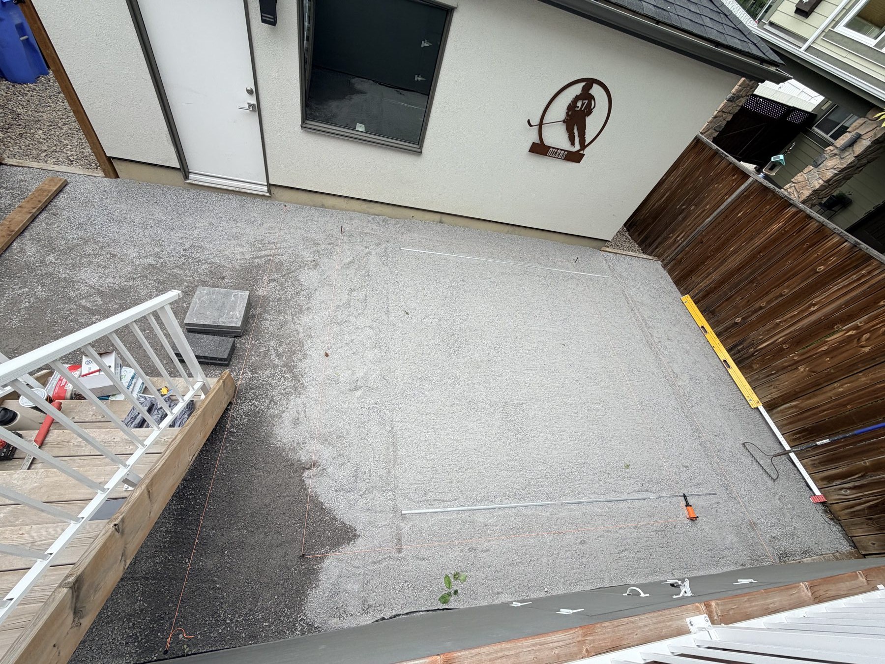 Exterior patio area being prepped with gravel, string lines, and a level — 3505 41 Street SW, Calgary