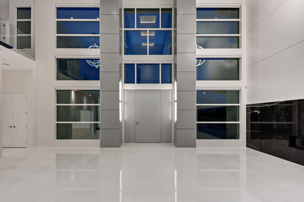 Modern foyer with polished white floor and floor-to-ceiling windows — Blanc de Blanc