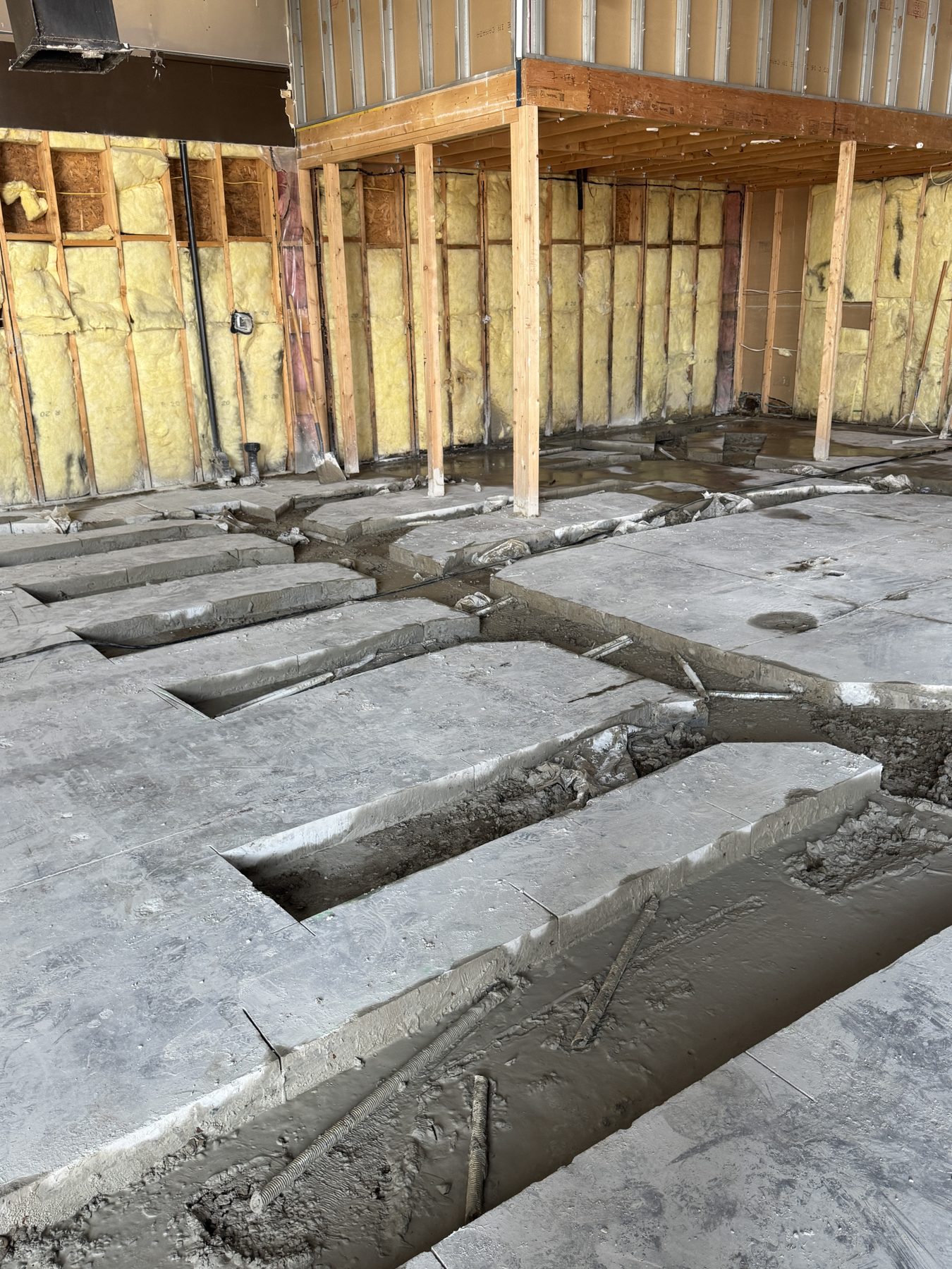 Concrete slab trenches dug for plumbing with exposed wall insulation — Blowers and Grafton (Red Deer)