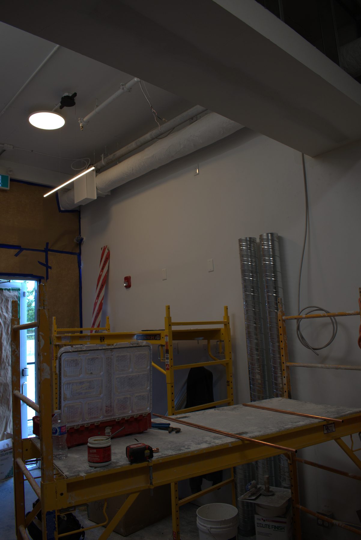 Construction project with scaffolding, ducting, and tools on a concrete floor — Big Buns (Bowness)