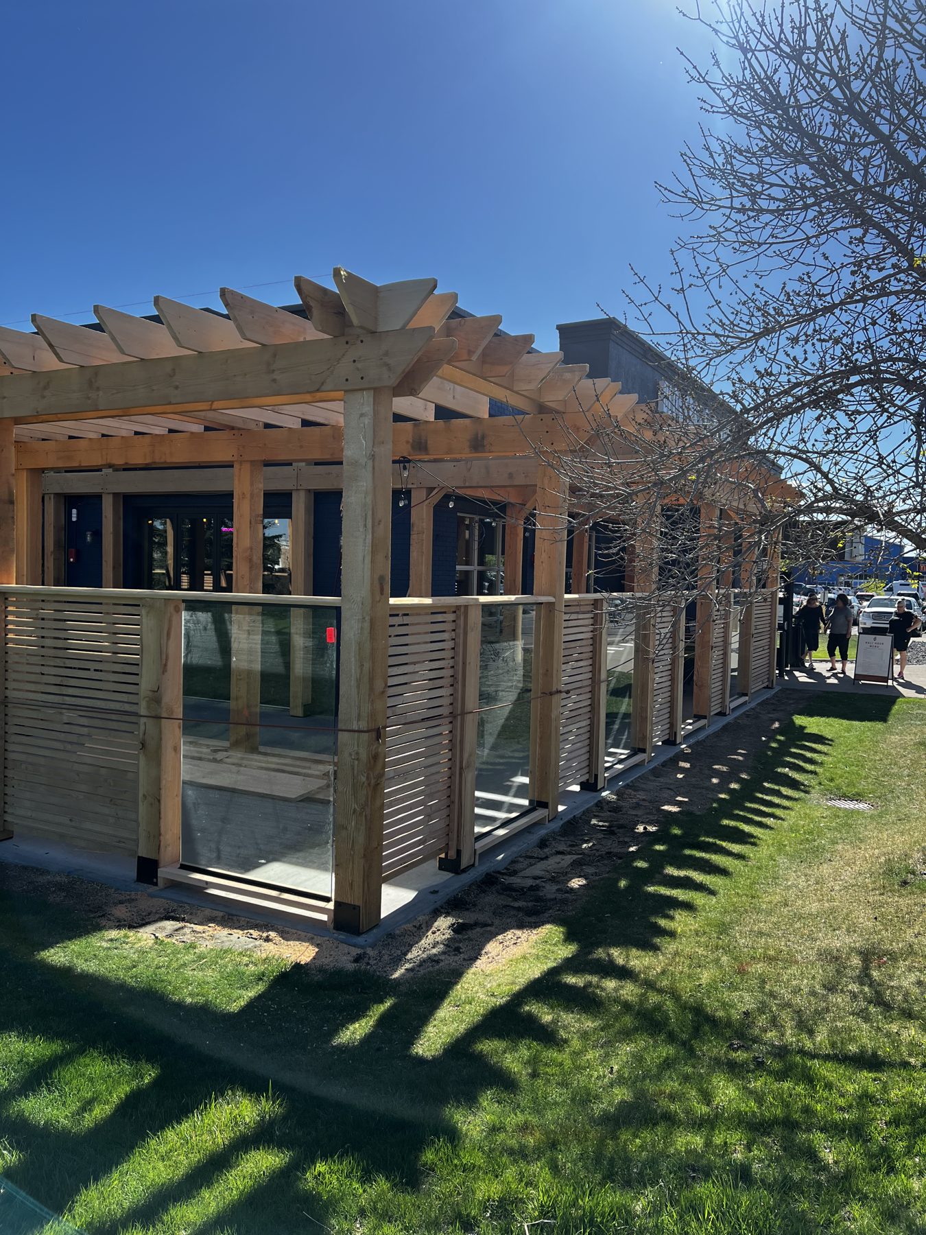 Wooden pergola and slatted fence with glass panels under construction — Blowers and Grafton (Lethbridge)