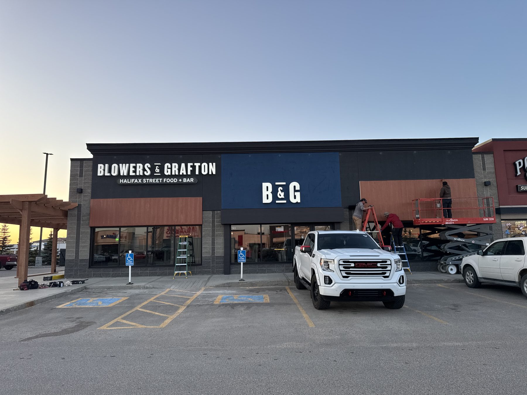 Workers install wooden panels on a commercial building exterior facade — Blowers and Grafton (Lloydminster)