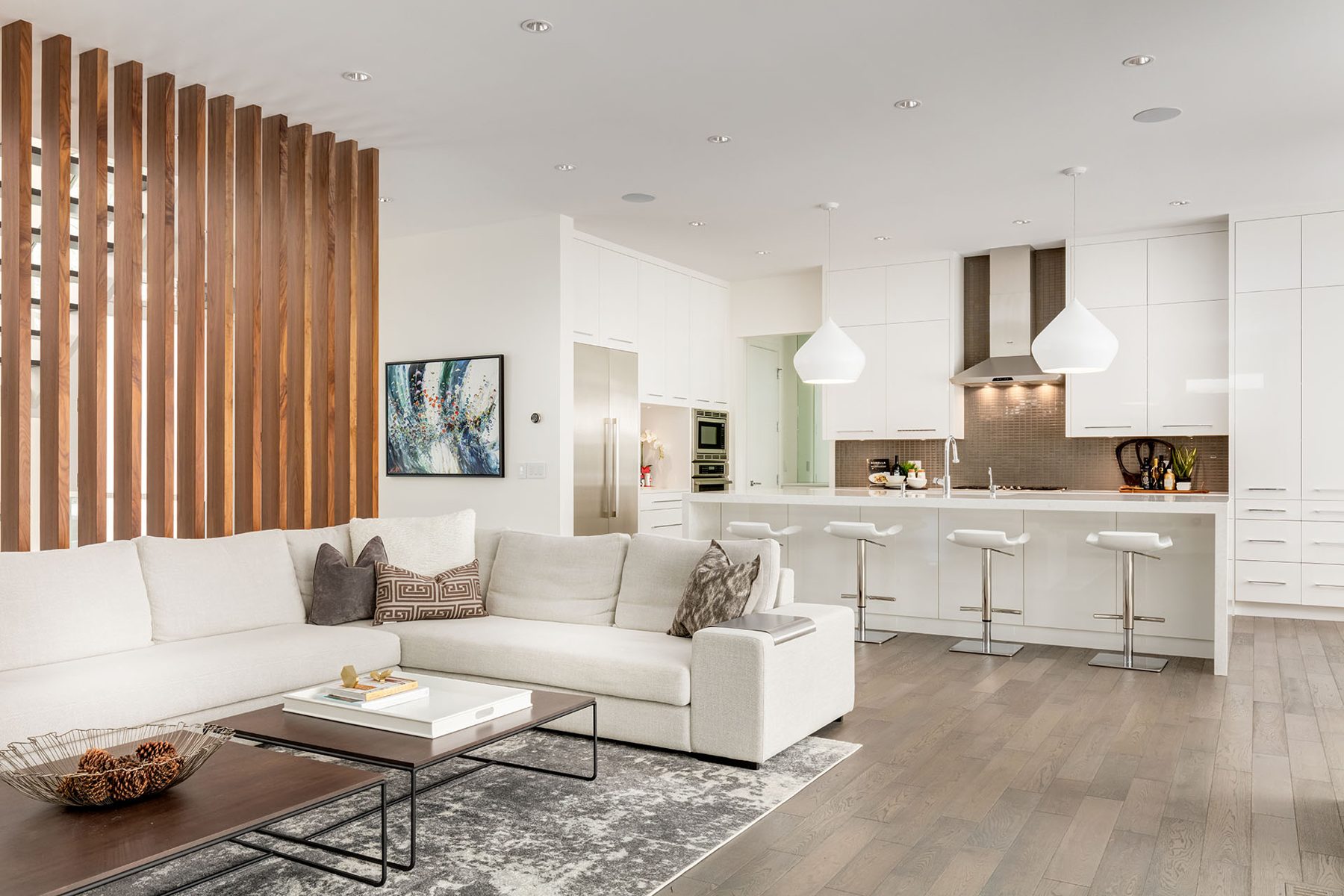 Modern open-concept living and kitchen area with sectional sofa and island — Casa Blanca