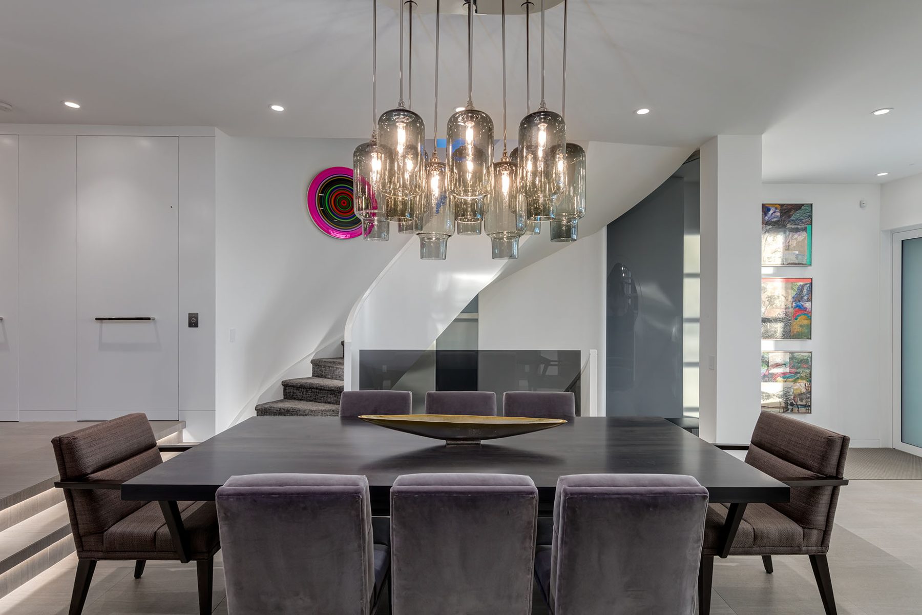 Modern dining room with dark table, velvet chairs, and abstract art — Skyline