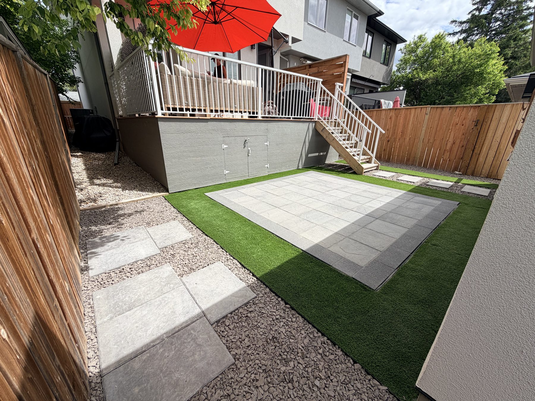 Patio with pavers, artificial turf, gravel, and stepping stones near deck — 3505 41 Street SW, Calgary