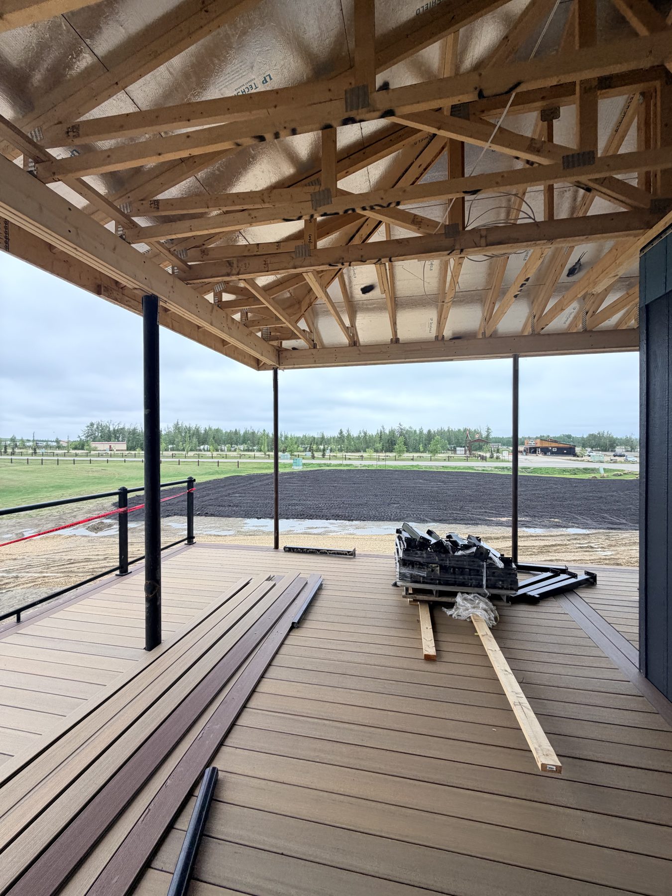 Covered deck construction with visible framing, insulation, and composite decking materials — Sandy Point (Club House)