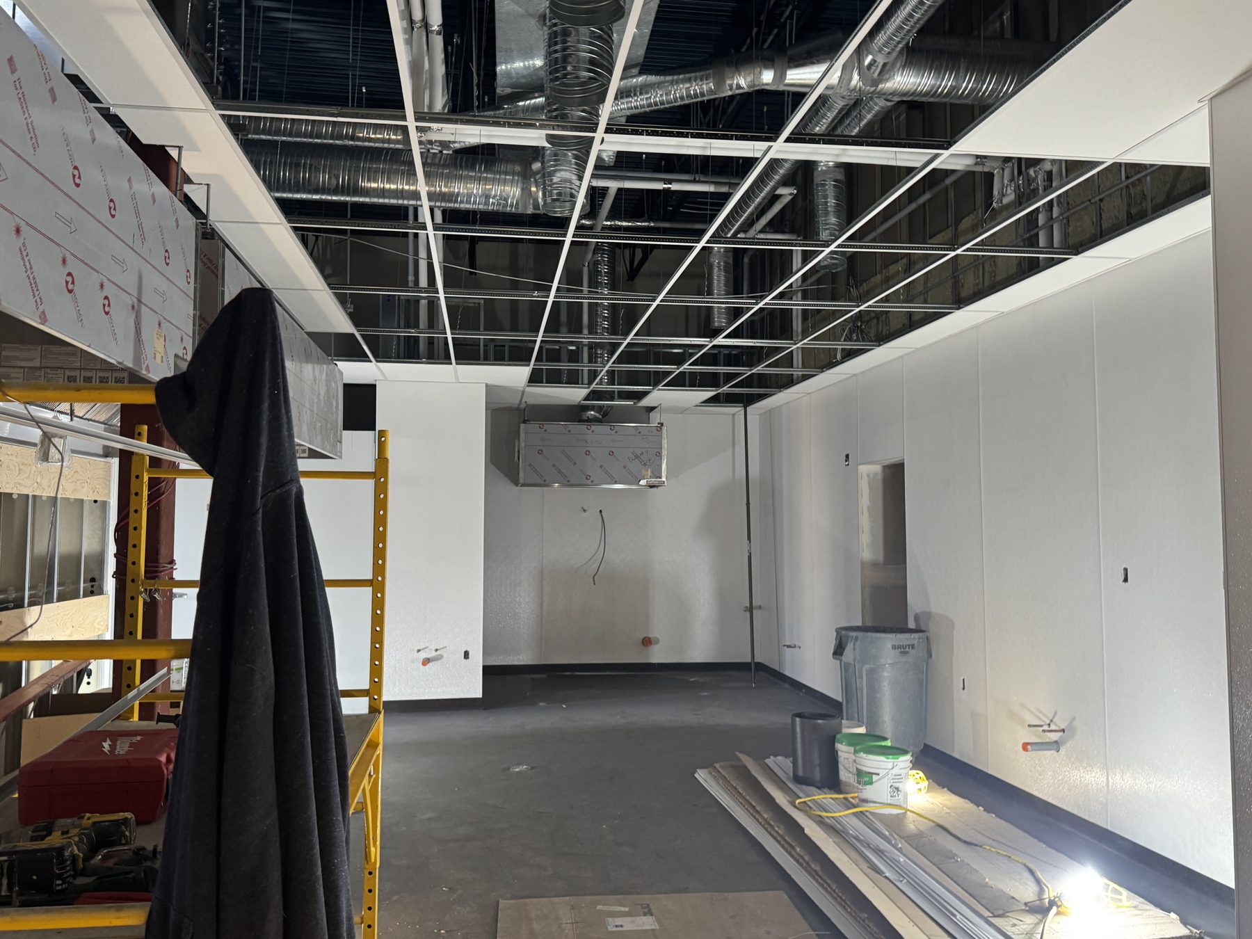 Under construction room with exposed ductwork and unfinished ceiling panels — Blowers and Grafton (Red Deer)