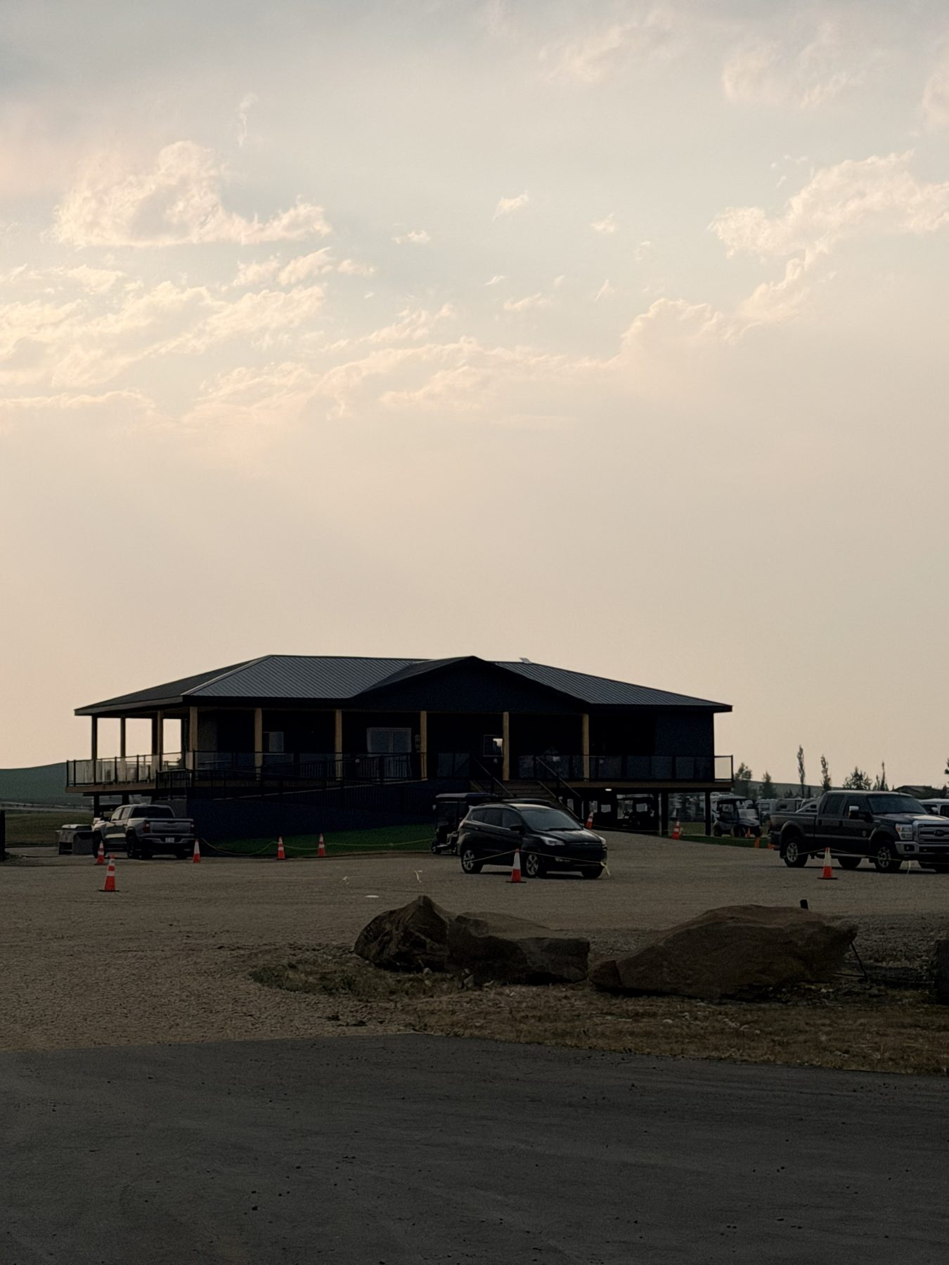 Dark building with porch, cars parked, and construction cones — Sandy Point (Club House) by Onsite Contracting Services