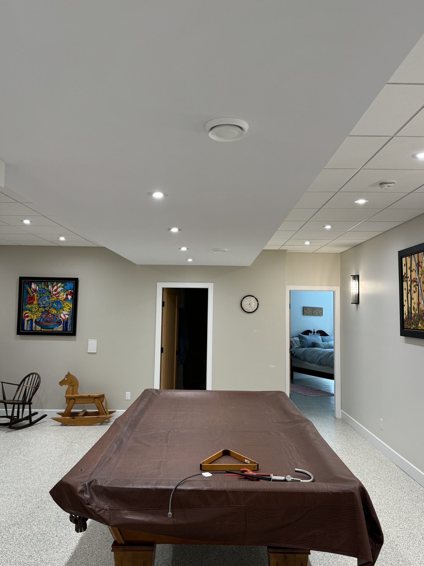 Basement renovation with covered pool table, new ceiling, and bedroom visible — 18 Varsplain Place Northwest