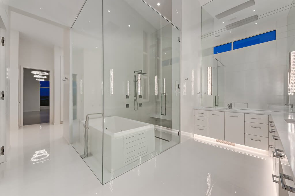 Modern white bathroom with glass shower enclosure, tub, and vanity — Blanc de Blanc