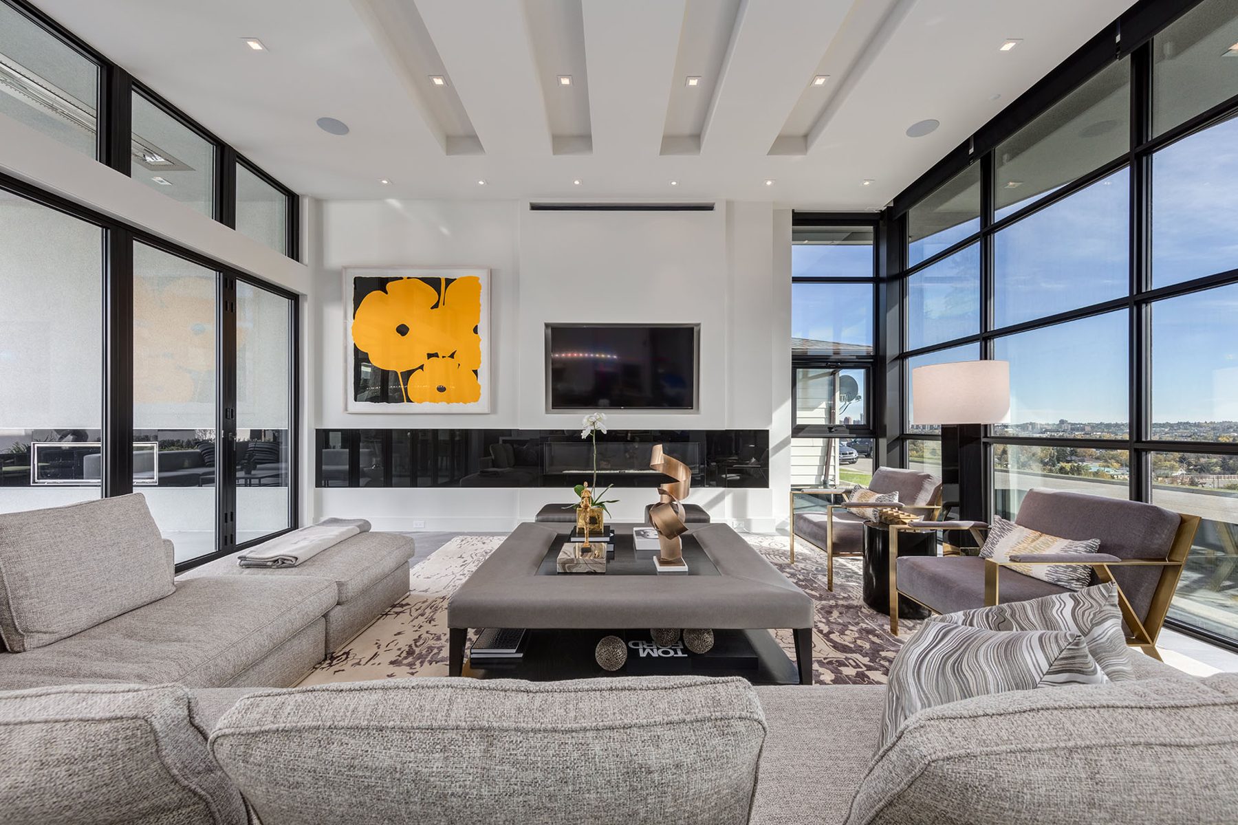 Modern living room with large windows, fireplace, and gray sectional sofas — Infinity