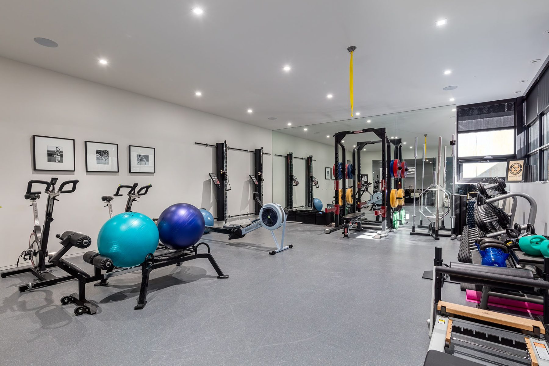 Home gym with cardio equipment, weight racks, and free weights — Infinity