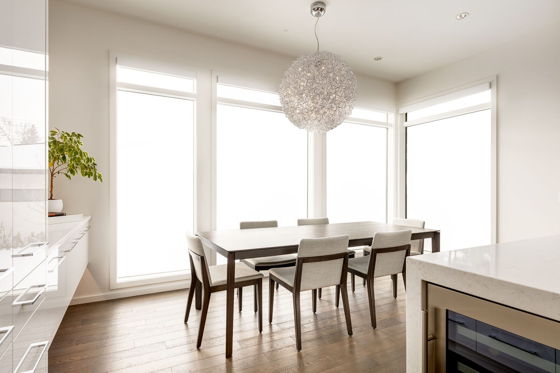 Modern dining room with wood floor, contemporary table and chairs — Casa Blanca