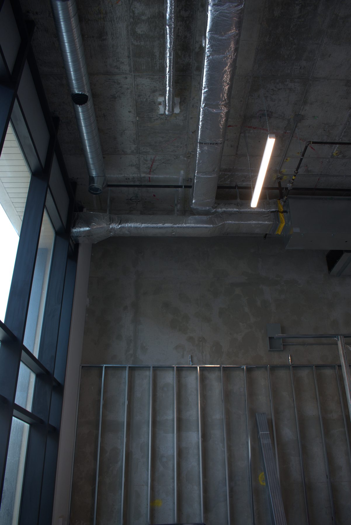 Exposed ductwork, metal studs, and unfinished concrete walls — Leela Spa (West District)