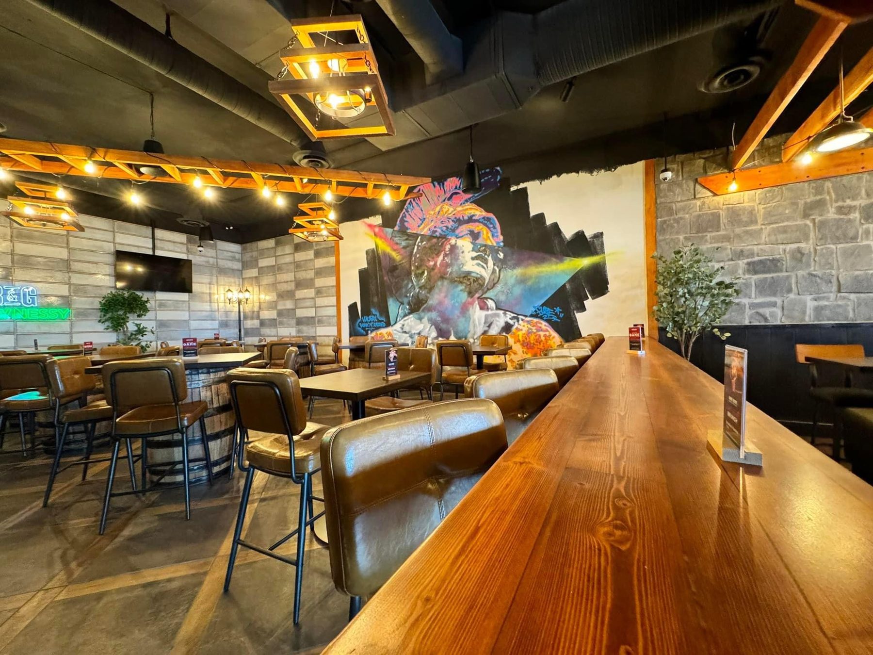 Bar and dining area with wood accents, stone walls, and mural — Blowers and Grafton (Shawnessy)