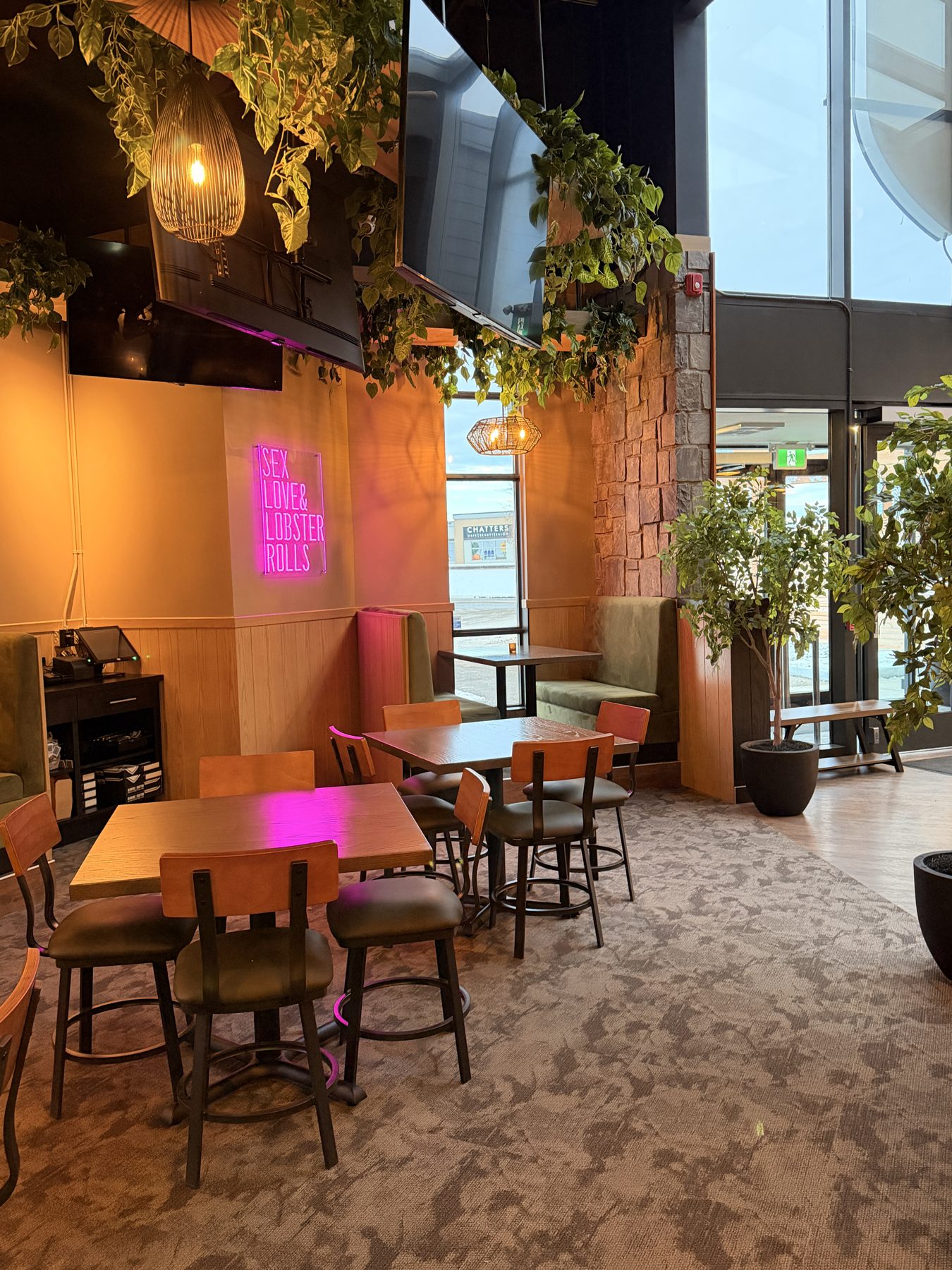 Restaurant dining area with wood paneling, neon sign, and booth seating — Blowers and Grafton (Red Deer)