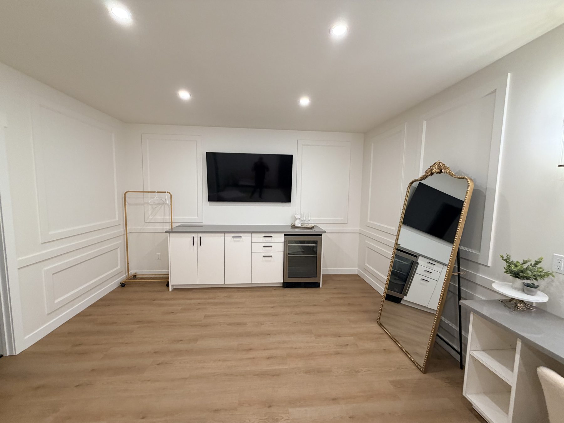 Living room renovation with paneled walls, new flooring, and built-in cabinets — The Barron Venue
