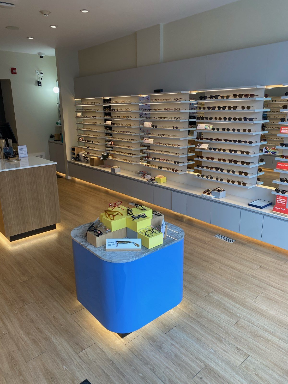 Eyeglass display shelves stocked with various frames in a modern retail space — 104 10 Street Northwest, Calgary (Bailey Nelson)