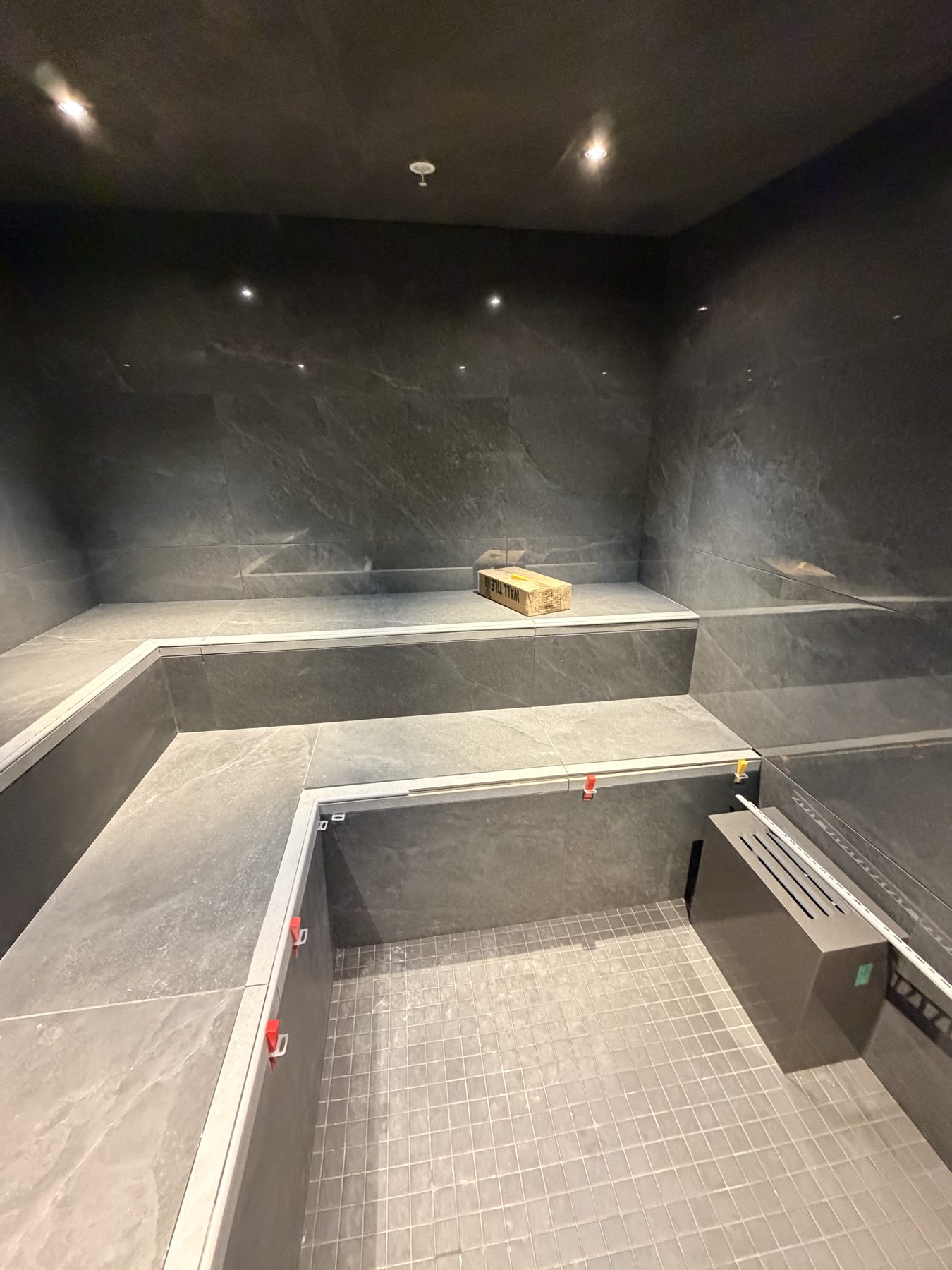 Modern steam room construction with large format slate tiles and tiled benches — Cedar Steam and Spa (Trinity Hills)