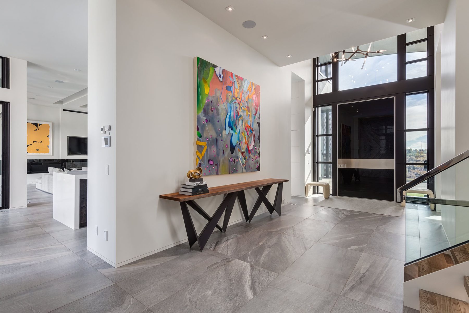 Luxury entryway with large format tile, modern console table, and abstract art — Infinity