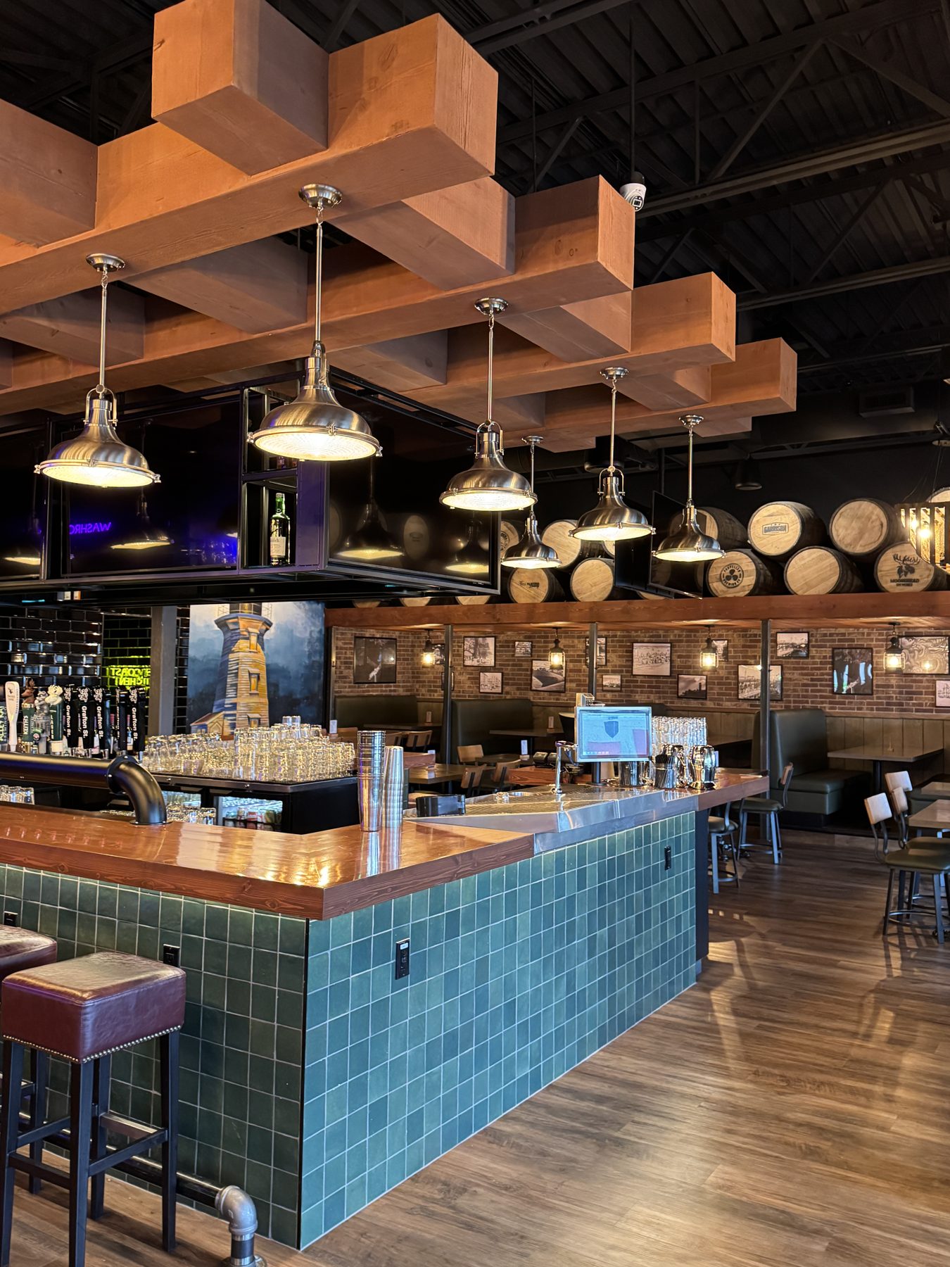 Bar with wood ceiling, green tile, and upholstered stools — Blowers and Grafton (Lloydminster)