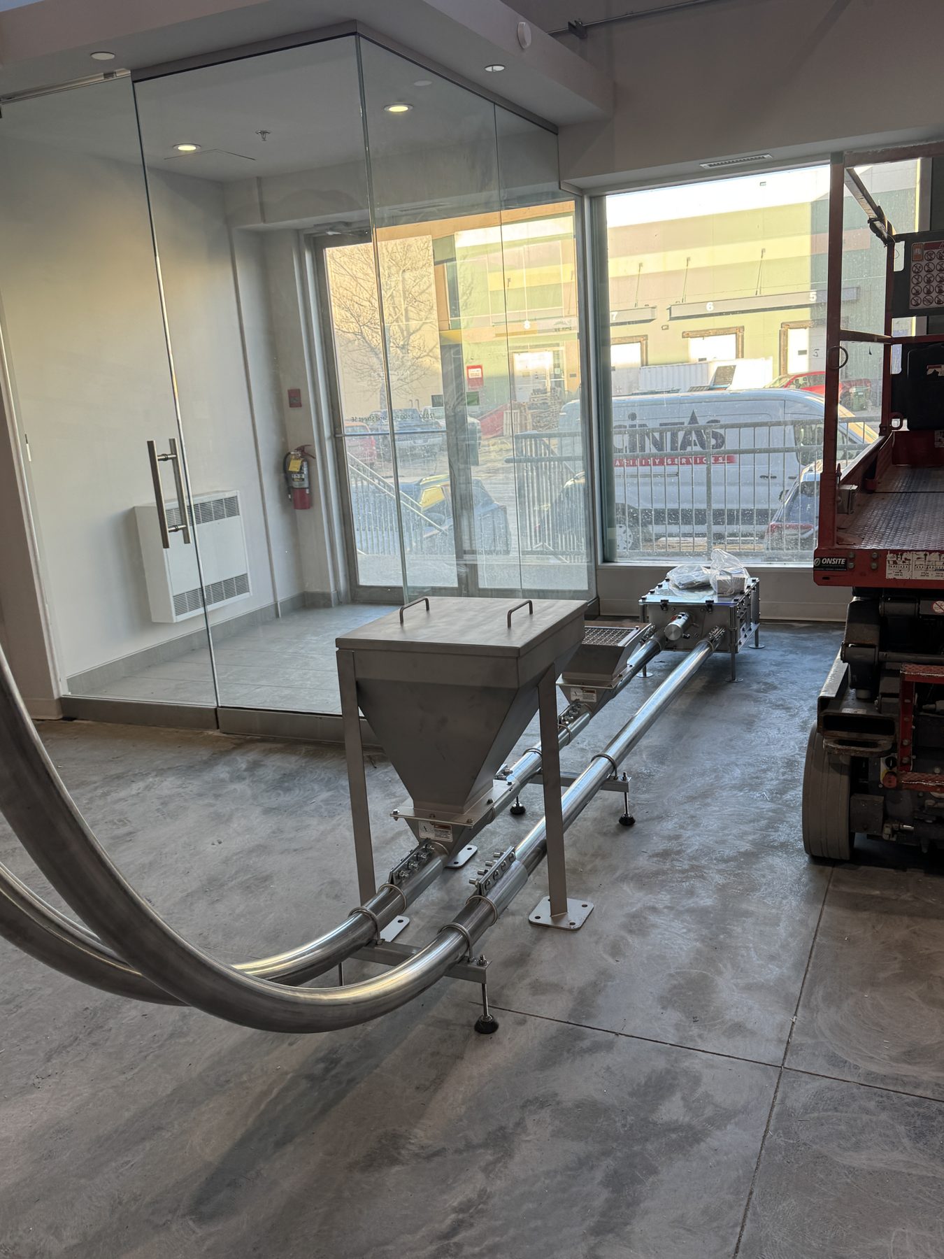 Stainless steel bulk material conveyor system installation in unfinished space — Eight Ounce Coffee