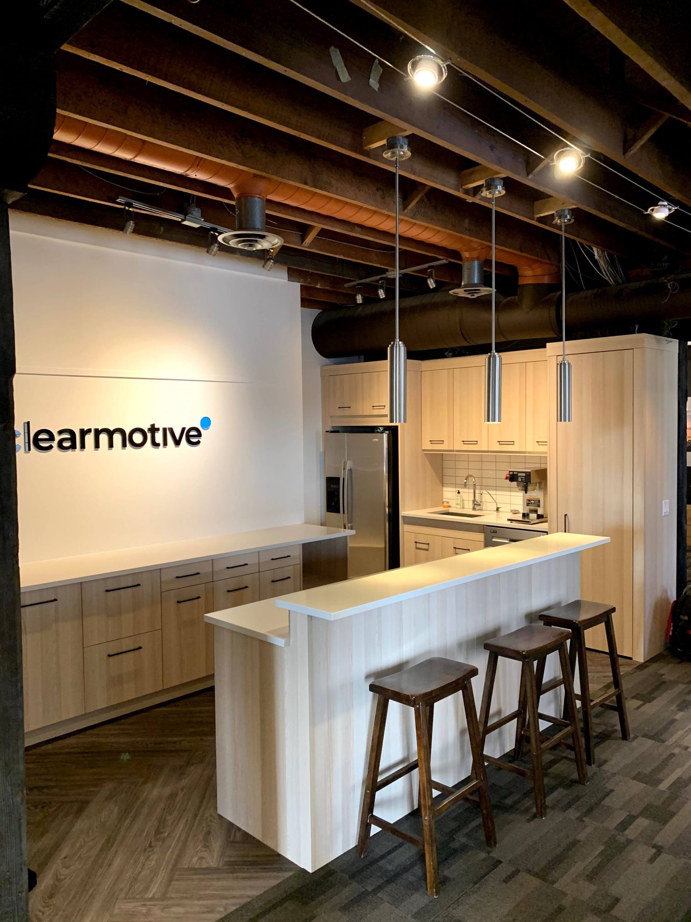 Modern kitchen with blonde wood cabinets, stainless steel appliances, and a breakfast bar — Clearmotive (Victoria Park)