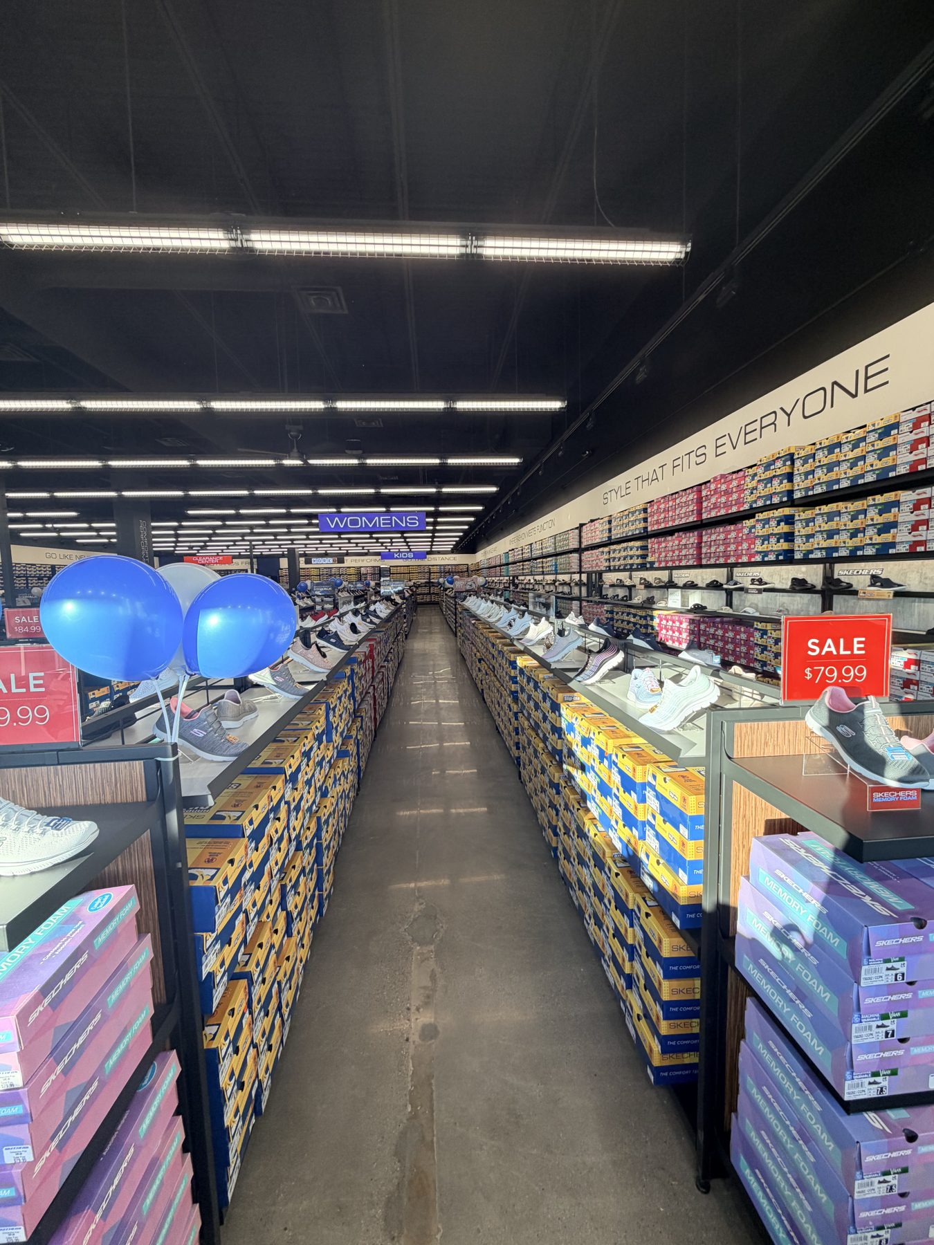Shoe store aisle with rows of shoe boxes and displays — Skechers (Signal Hill)