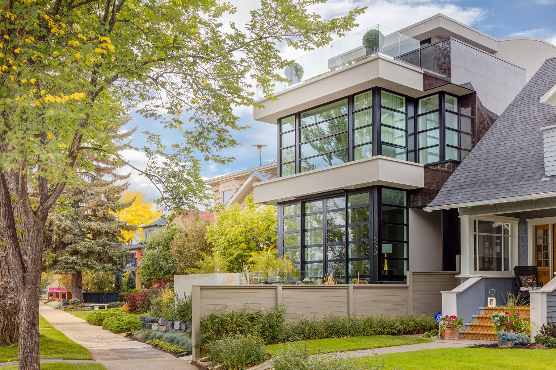 Modern home renovation with large windows, stone, and glass balcony — Skyline by Onsite Contracting Services