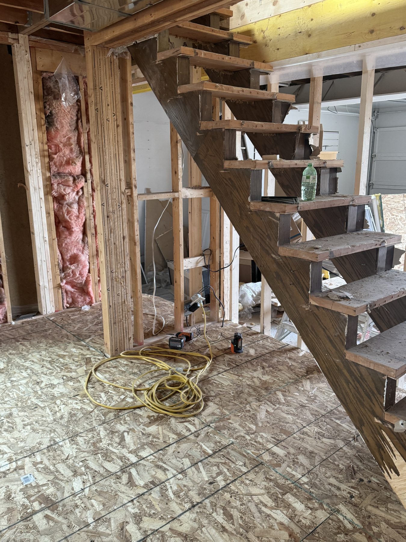 Staircase renovation in progress, with exposed insulation and OSB subfloor — 188 Lake Adams Crescent SE, Calgary