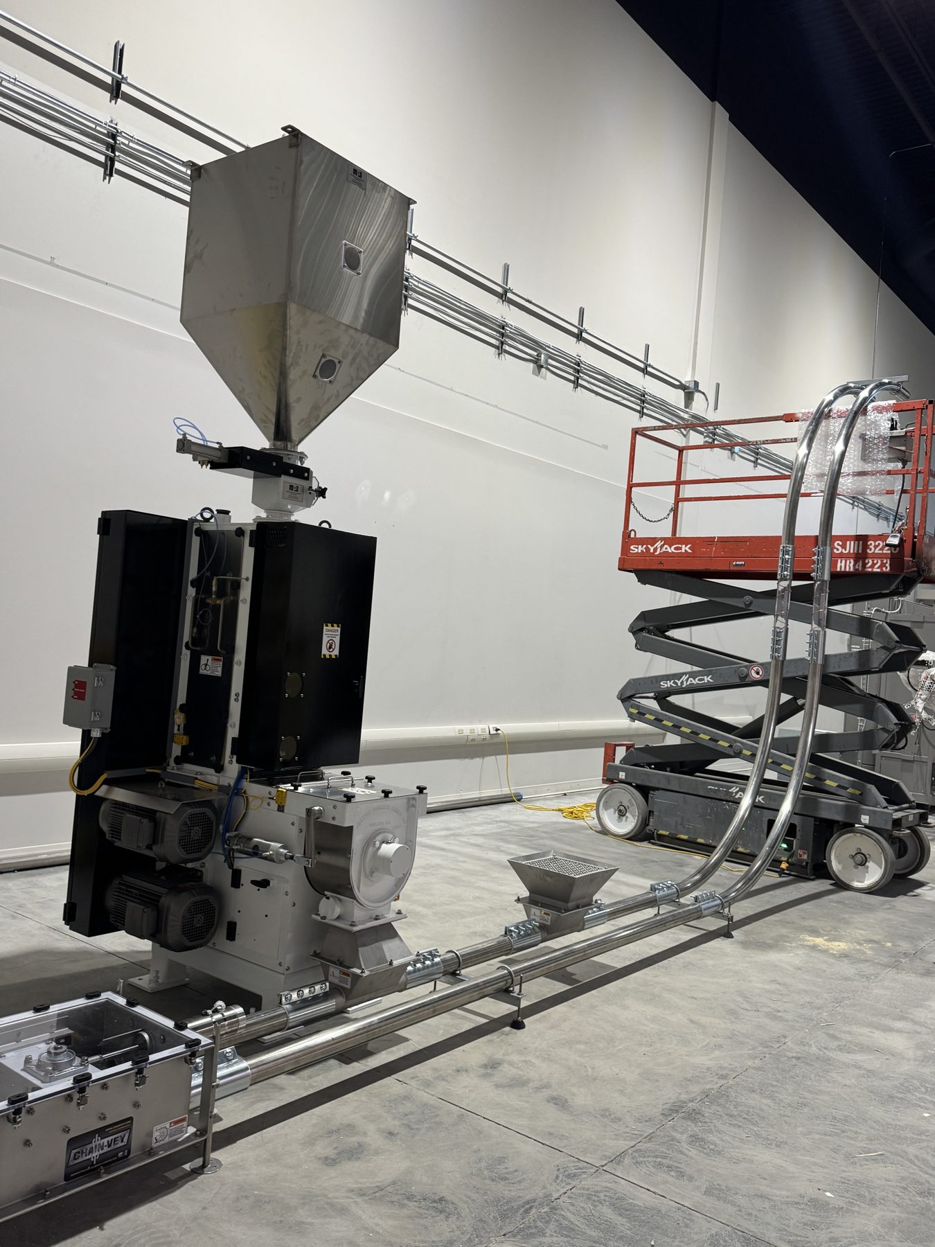 Industrial machine assembly with scissor lift and piping installation — Eight Ounce Coffee