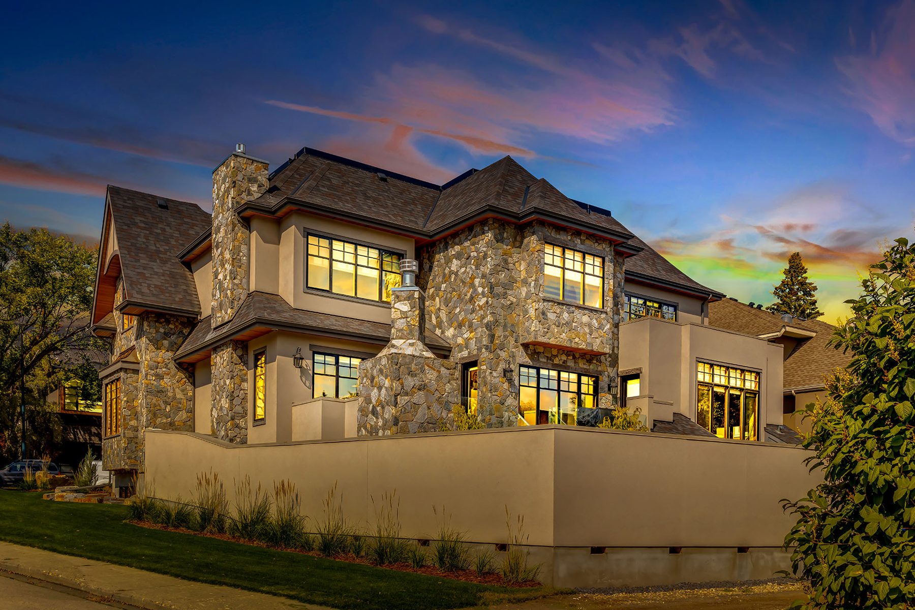 Luxury home exterior with stone accents, large windows, and dusk sky — Oxford by Onsite Contracting Services