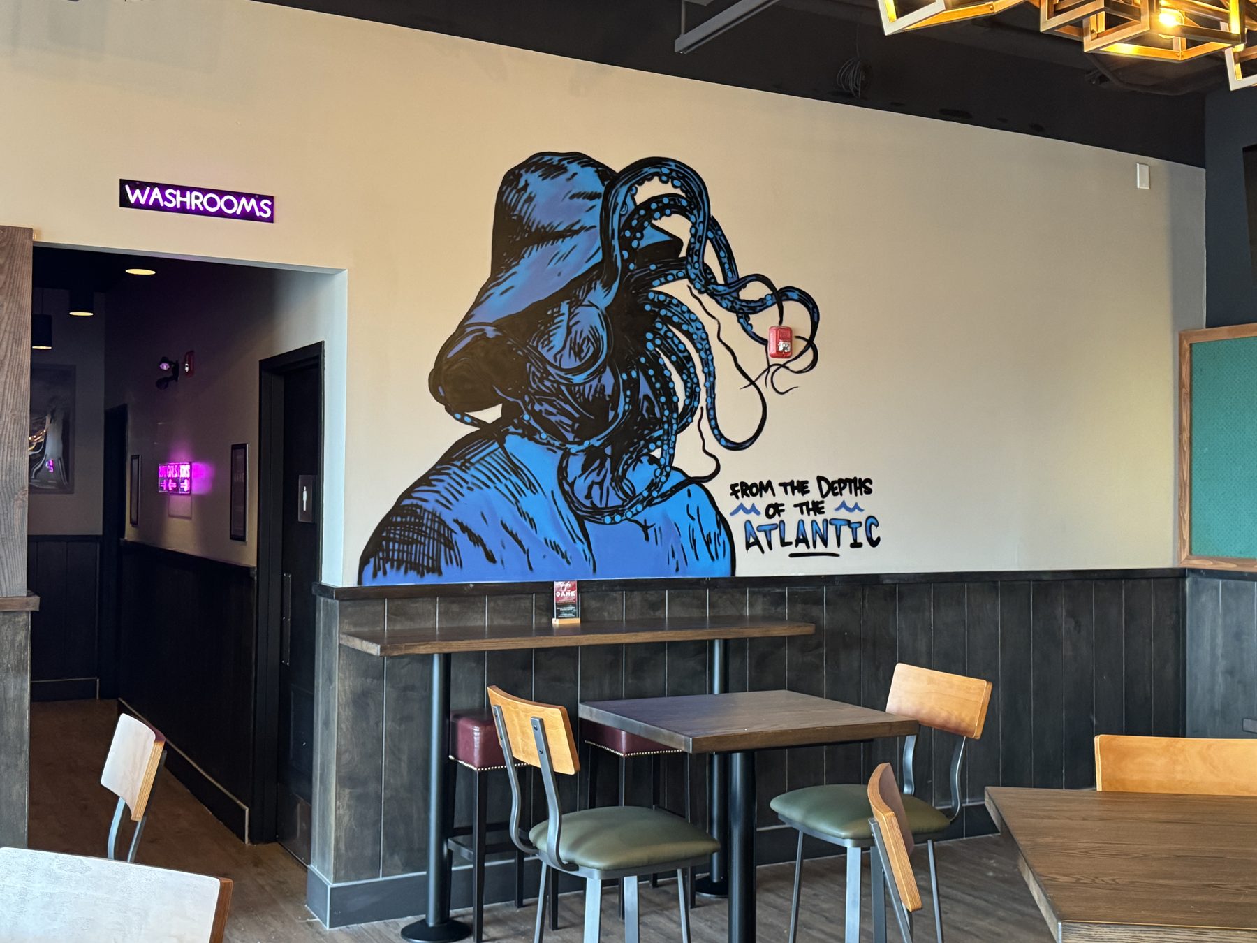 Restaurant dining area with octopus mural, tables, chairs, and washroom signage — Blowers and Grafton (Shawnessy)