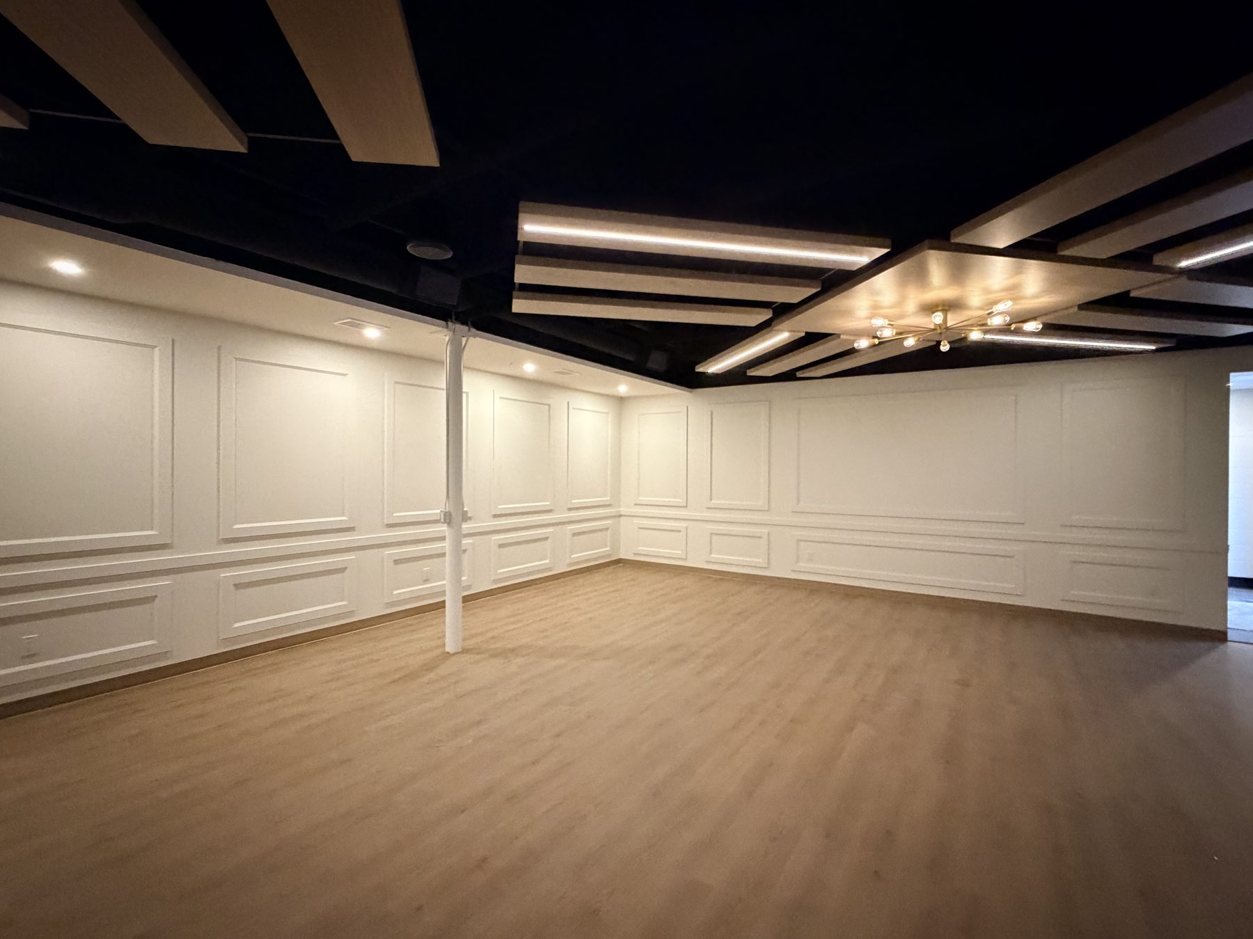 Newly renovated room with white wainscoting, recessed lighting, and wood flooring — The Barron Venue