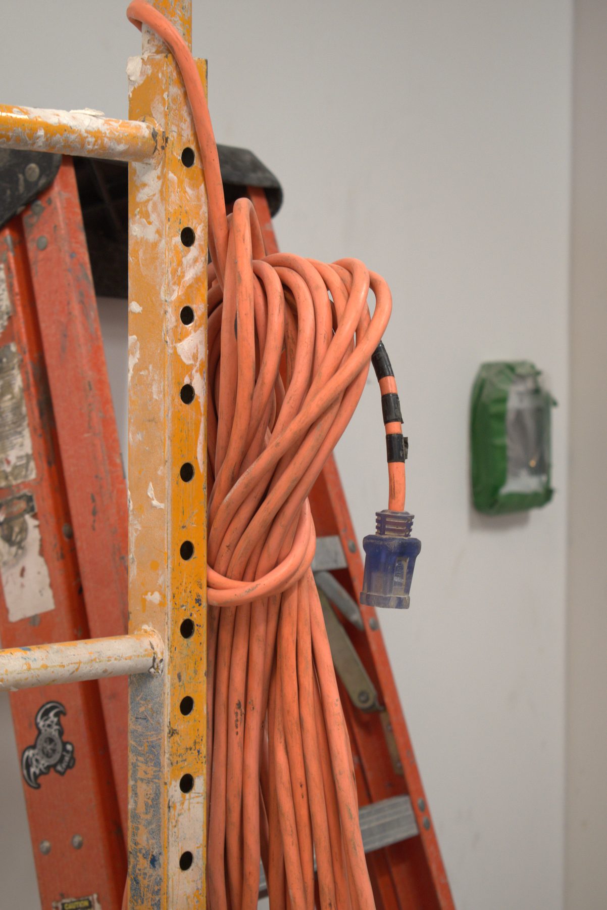 Orange extension cord on scaffolding next to a ladder — Big Buns (Bowness)