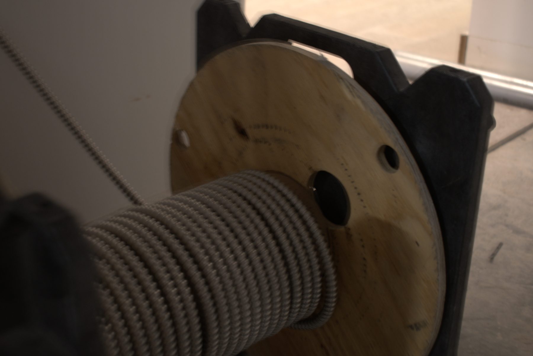 Large spool of electrical wire on wooden reel, construction in progress — Big Buns (Bowness)