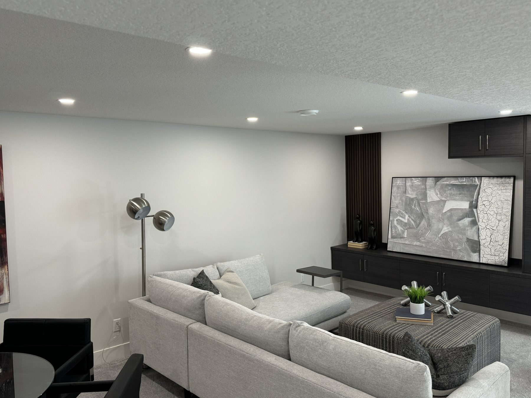 Newly renovated living room with gray sectional sofa and media console — Lake Bonavista