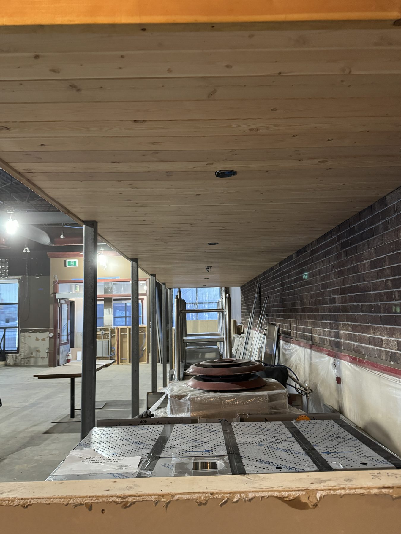 Wood plank ceiling, brick wall, construction materials, unfinished room — Blowers and Grafton (Medicine Hat)