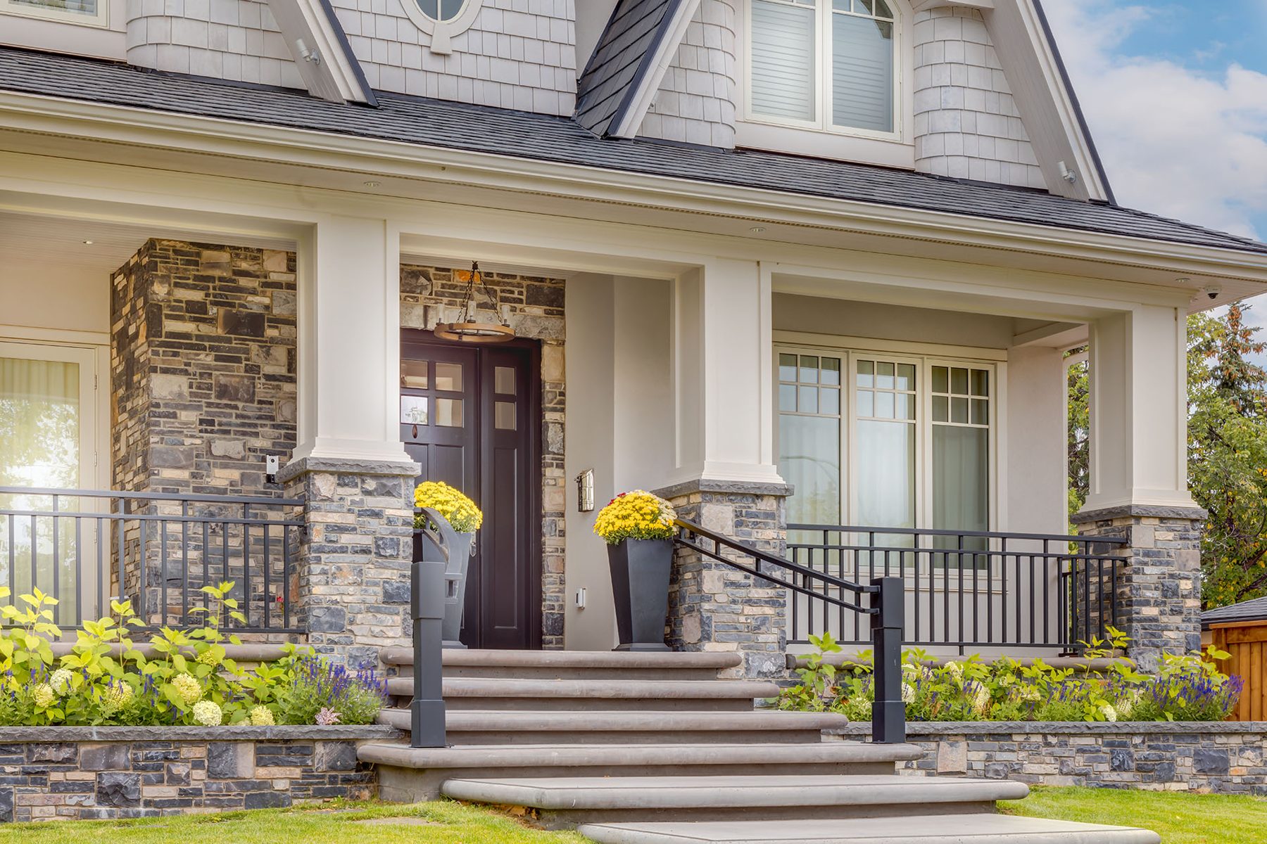 Stone and shingle home exterior with dark double doors and porch — White House