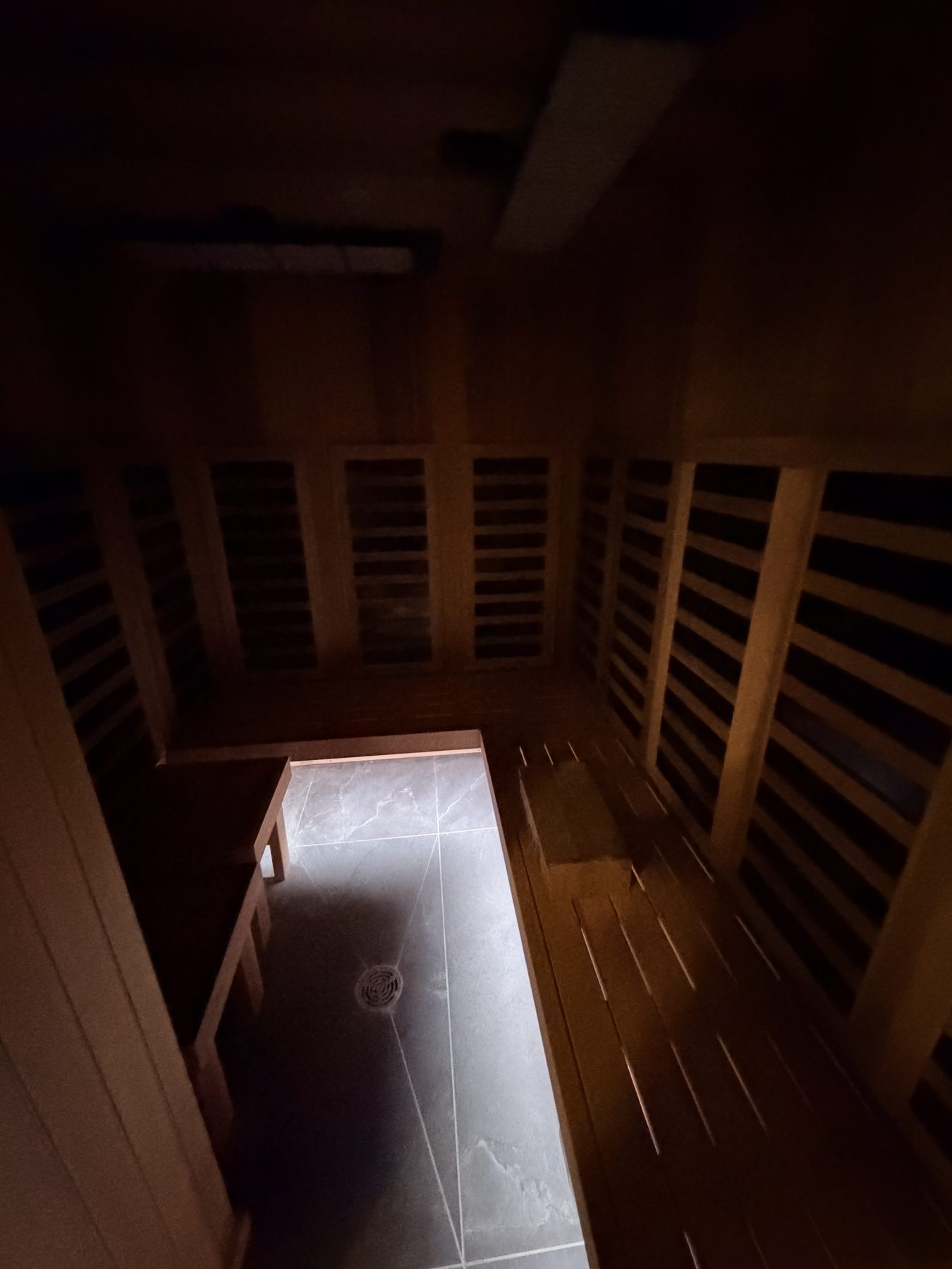Wooden sauna interior with tiled floor and drain fixture — Cedar Steam and Spa (Trinity Hills)