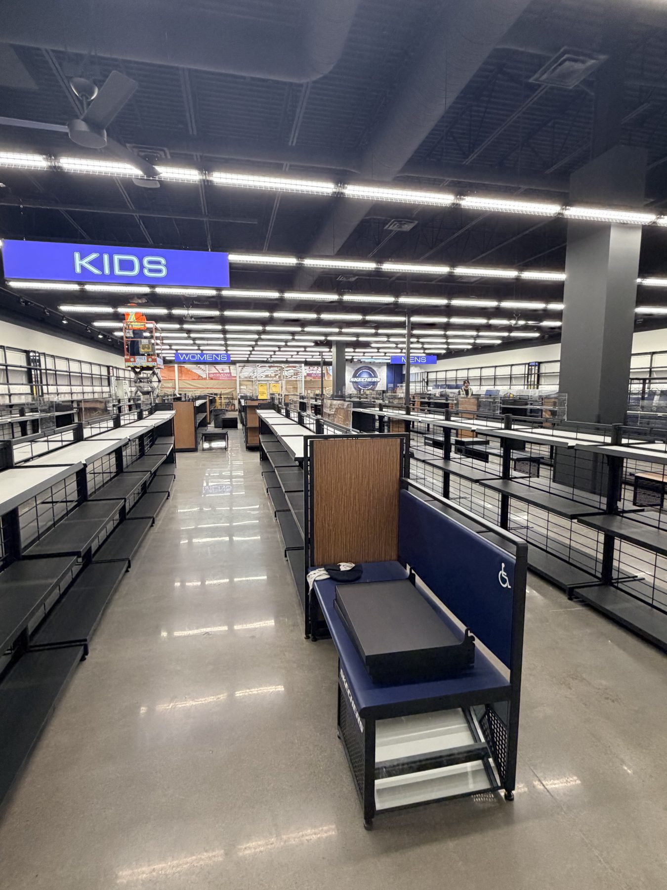 Store interior under renovation with empty shelves and new fixtures — Skechers (Signal Hill)