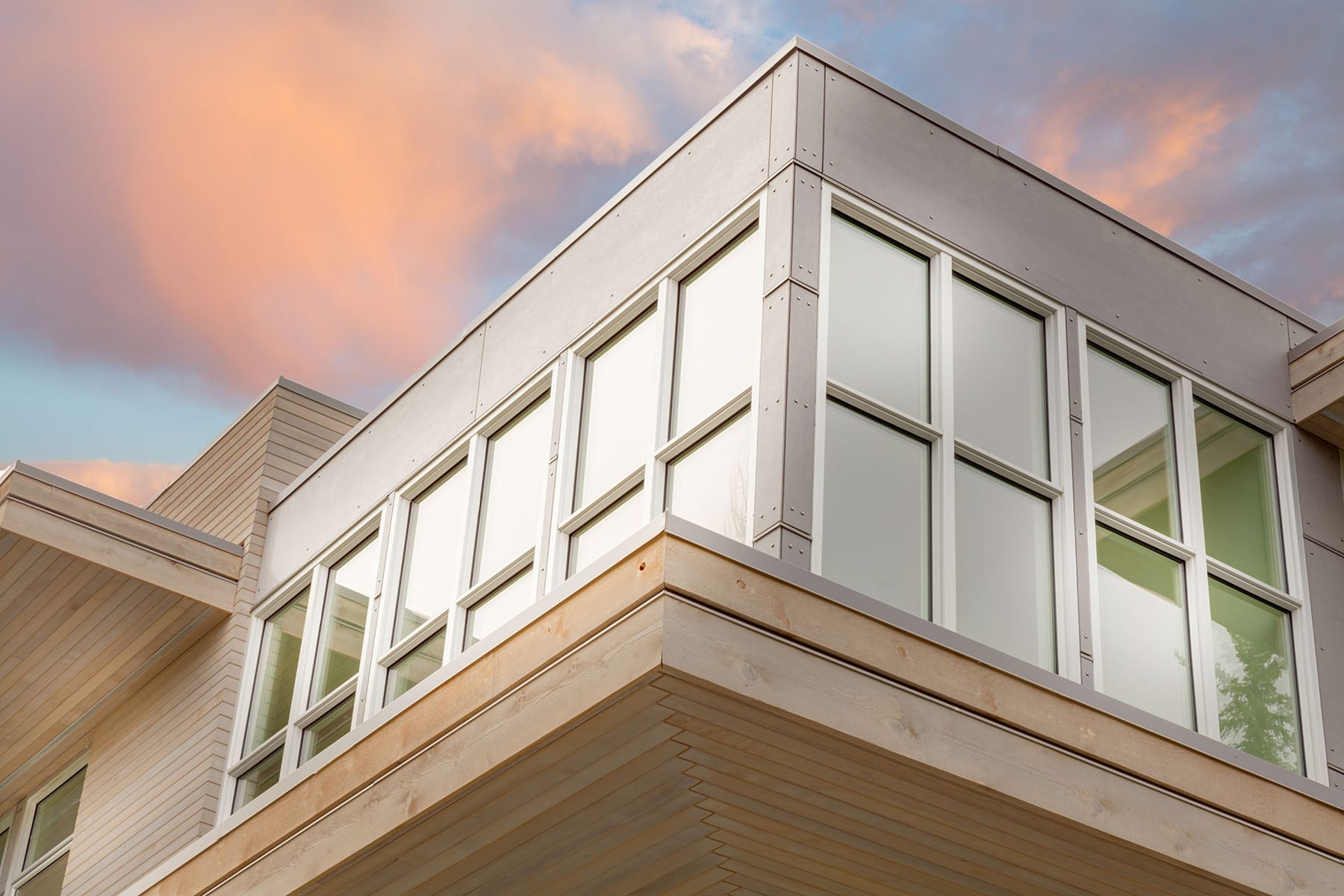 Modern building corner with wood siding and large windows — Germania