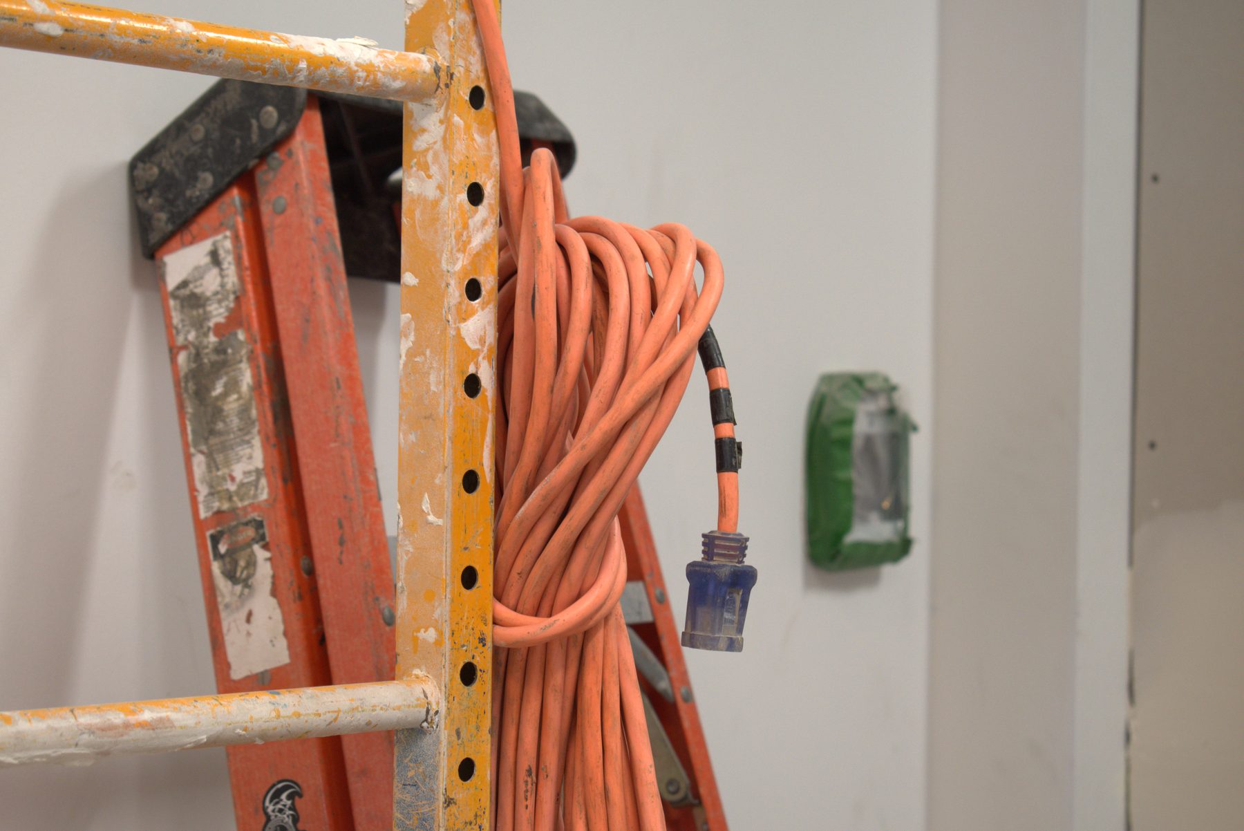 Orange extension cord hangs on scaffolding next to ladder — Big Buns (Bowness)