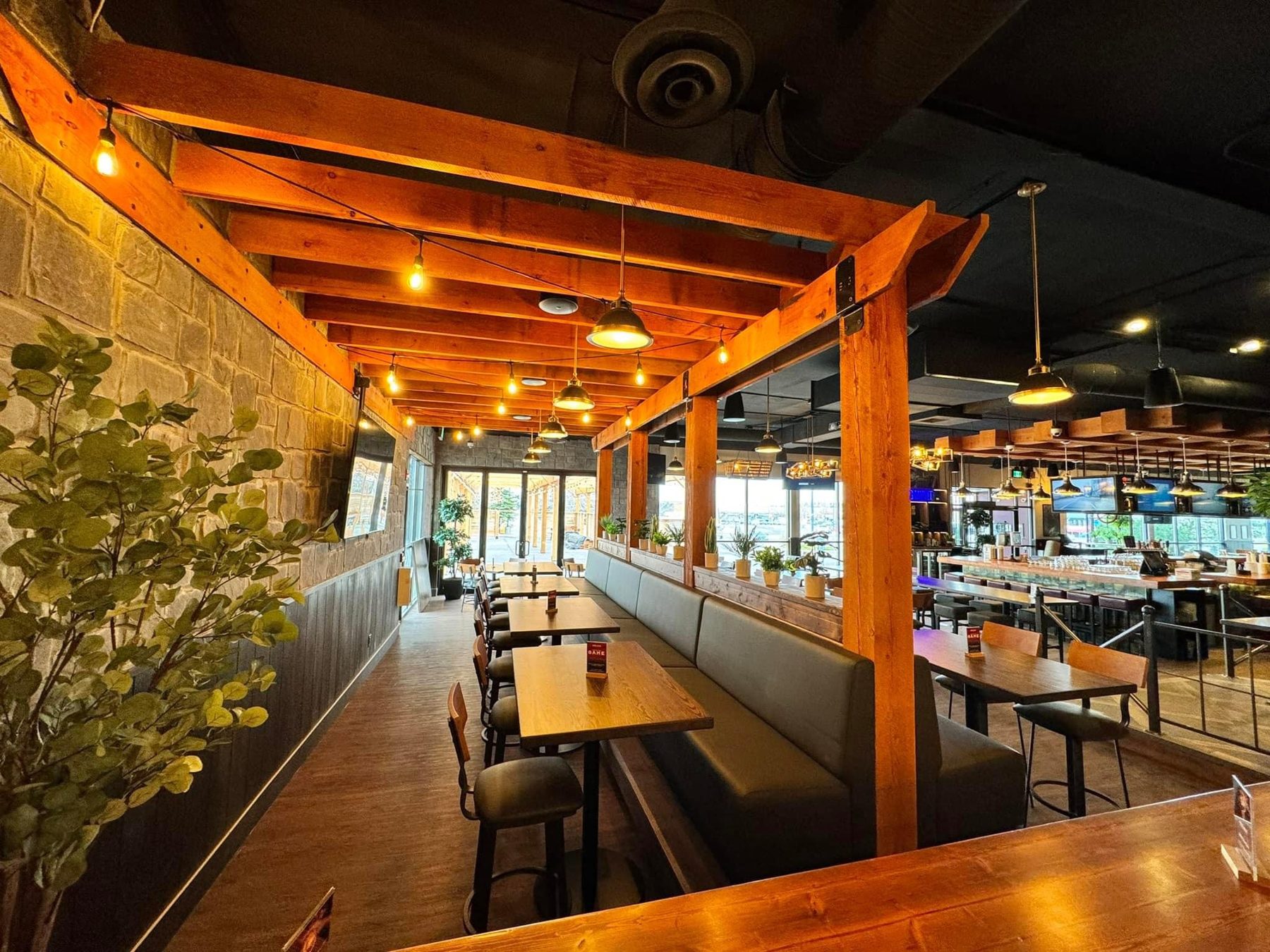 Restaurant dining area with wooden pergola, stone walls, and booth seating — Blowers and Grafton (Shawnessy)