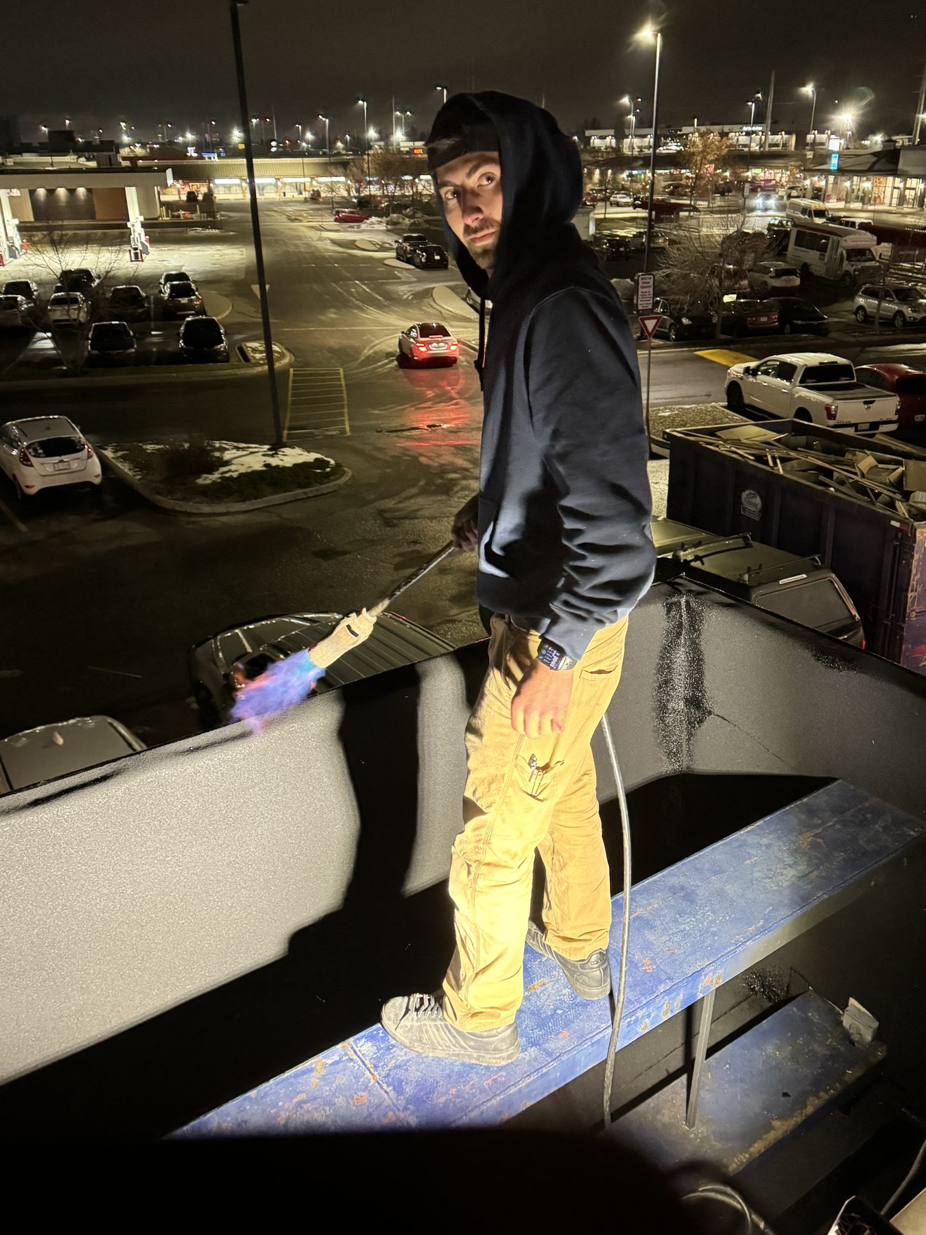 Worker using a torch on a rooftop, dumpster nearby — Blowers and Grafton (Shawnessy)
