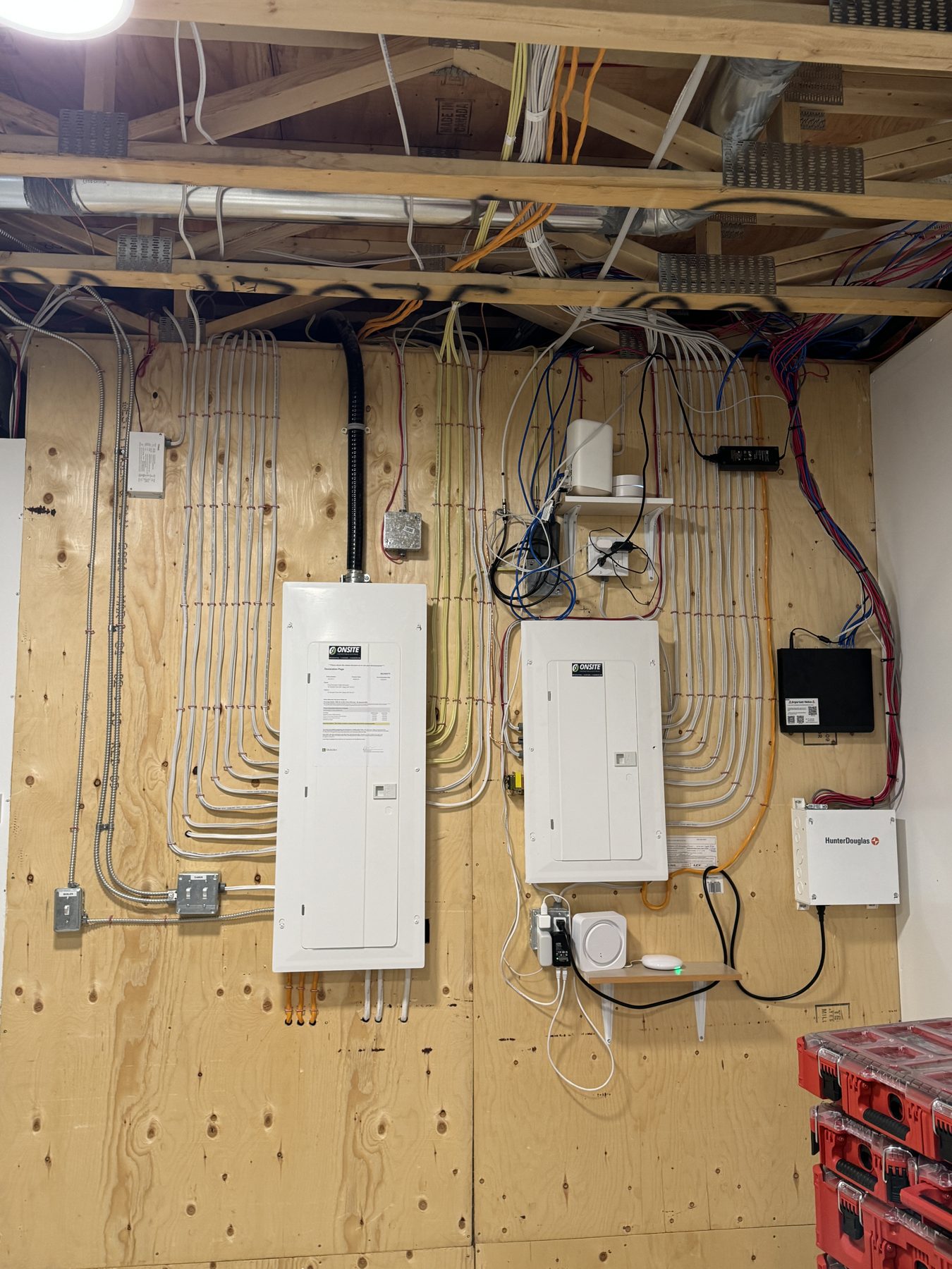 Electrical panels, network equipment, and wiring on unfinished plywood wall — 18 Varsplain Place Northwest