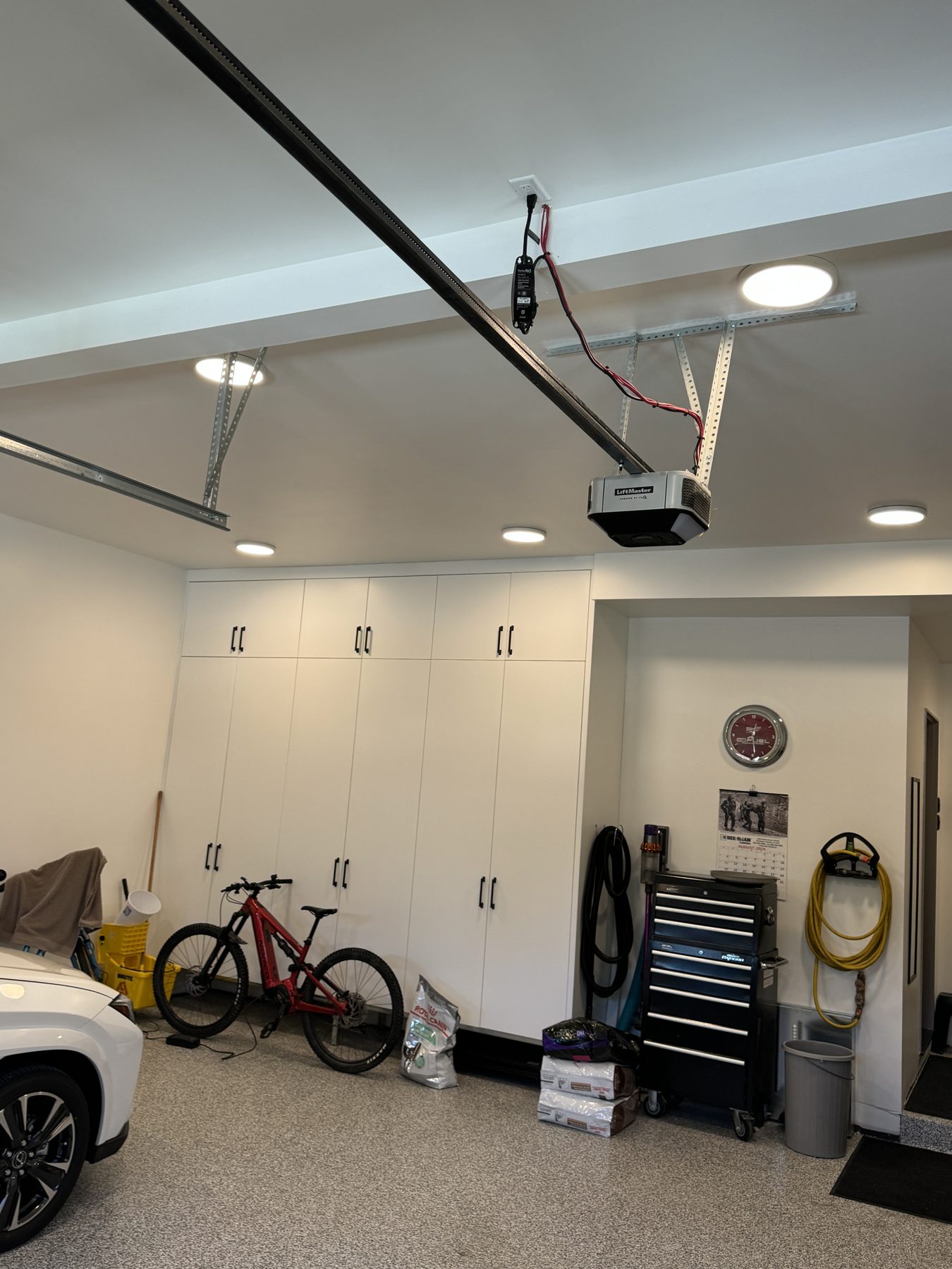 Newly renovated garage with white cabinets, bike, and car — 18 Varsplain Place Northwest