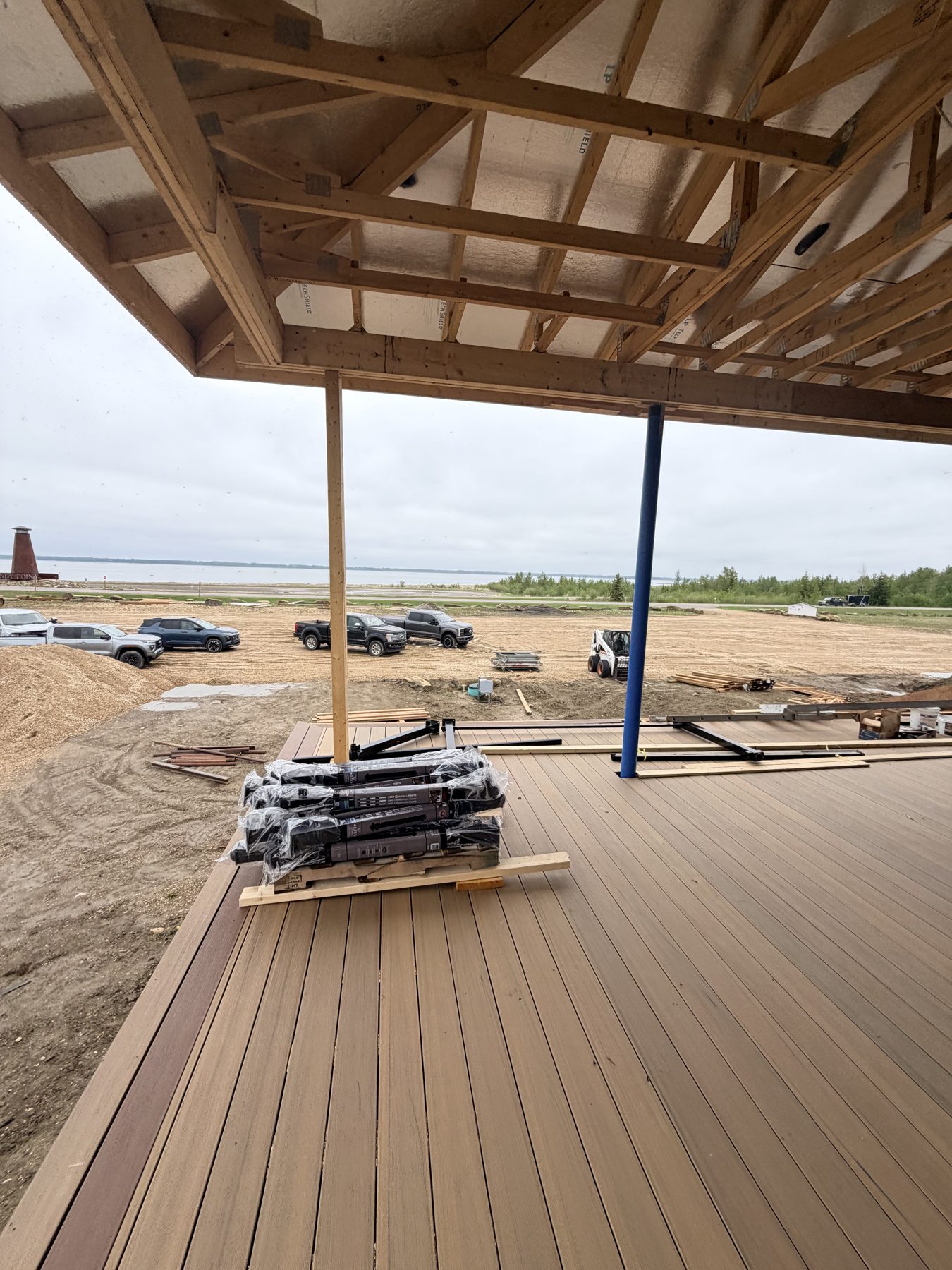 Deck construction, with framing, decking, and stacked materials — Sandy Point (Club House)